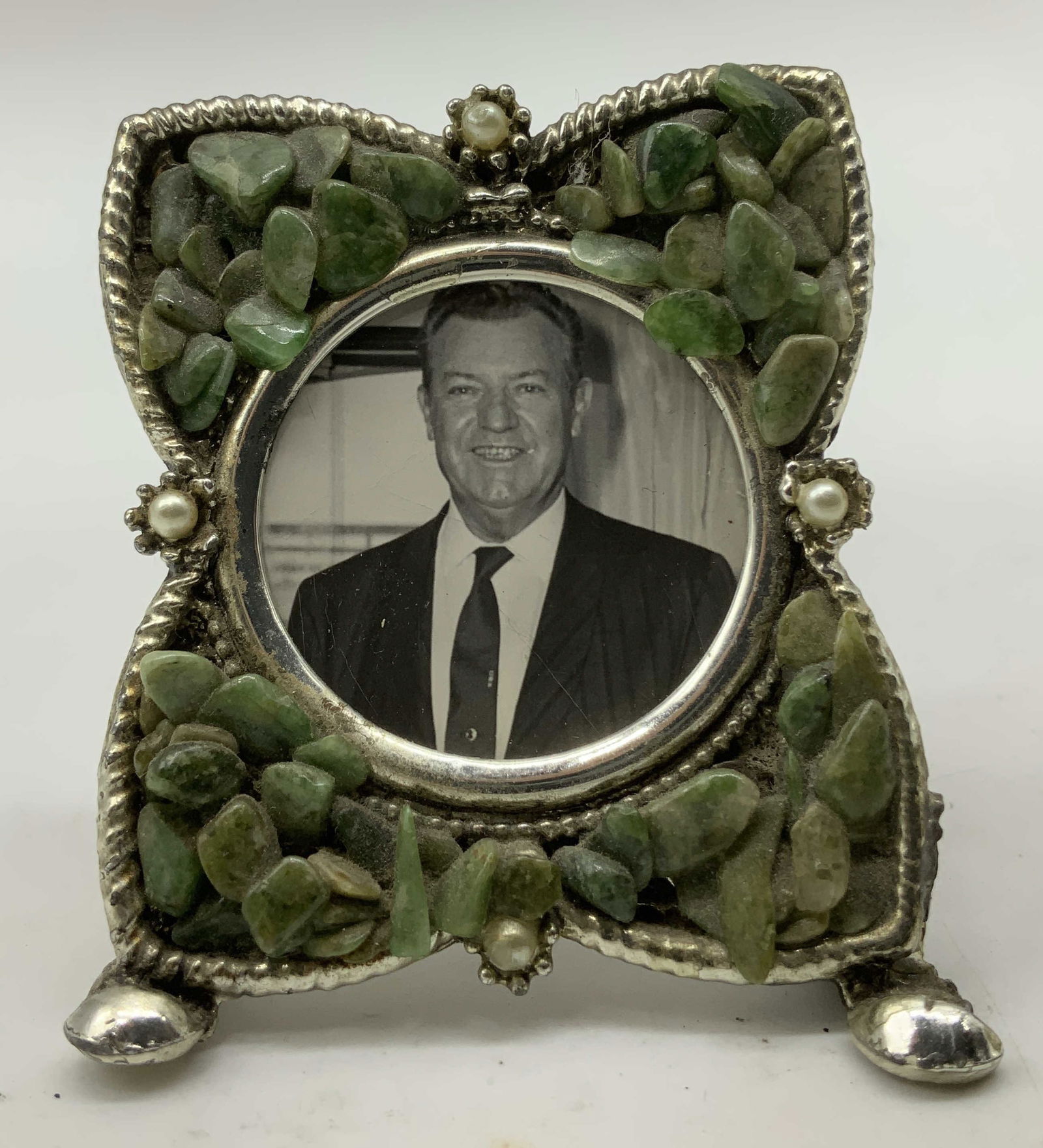 Vntg Silver Toned & Stone Picture Frame: Vintage frame features a silver toned finish & adorned with clustered green stones. 2 faux pearl at top & bottom. Center contains a portrait of a man. No visible signature or markings, surface wear co