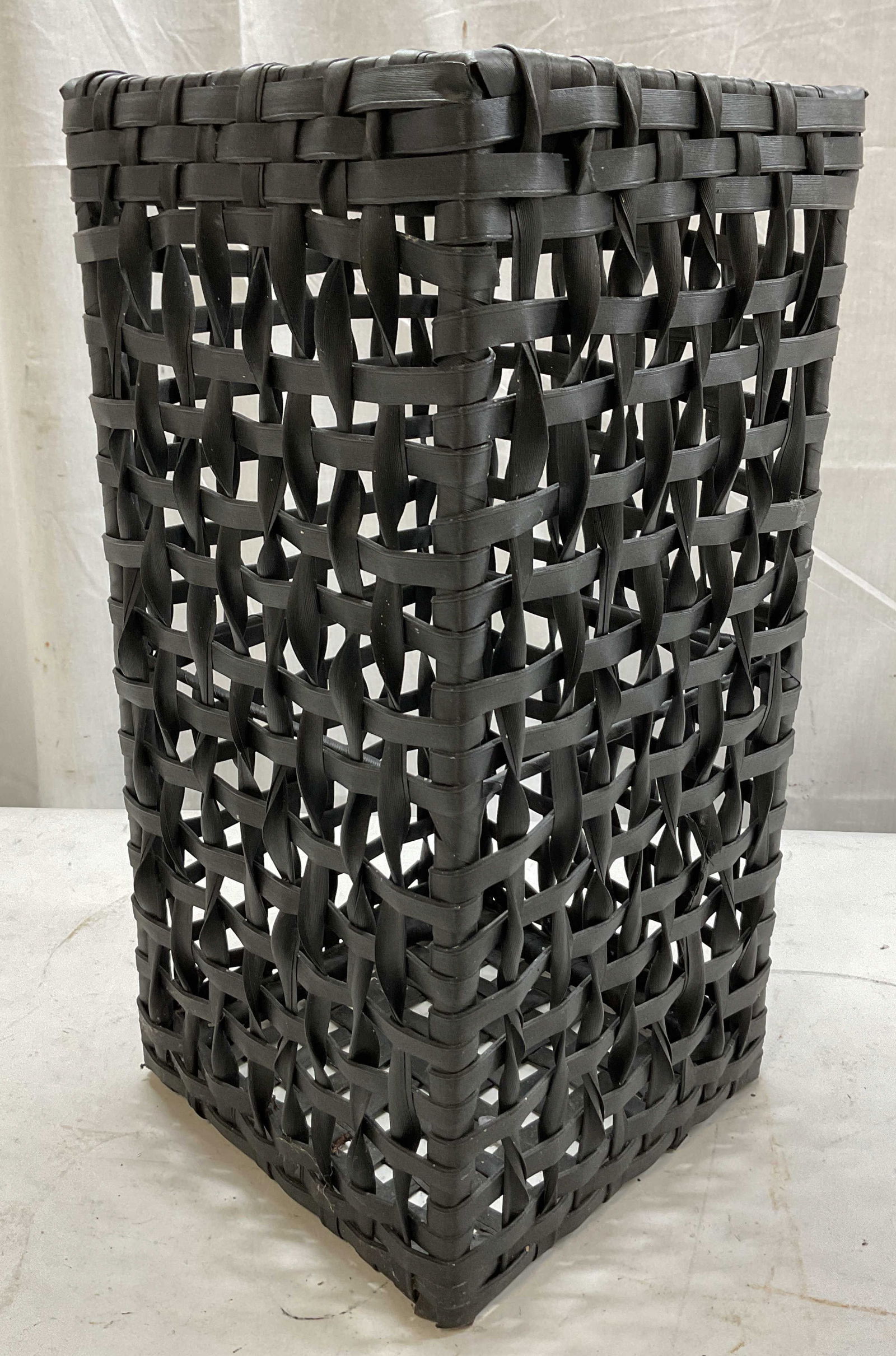 Vintage Black Woven Waste Basket: Vintage black woven waste basket. Intricate weave pattern. Rectangular shape. Measures approx 8.5 x 8.5 x 18 inches. Surface wear consistent with exposure. Waste basket, bin, basket, home decor, decor