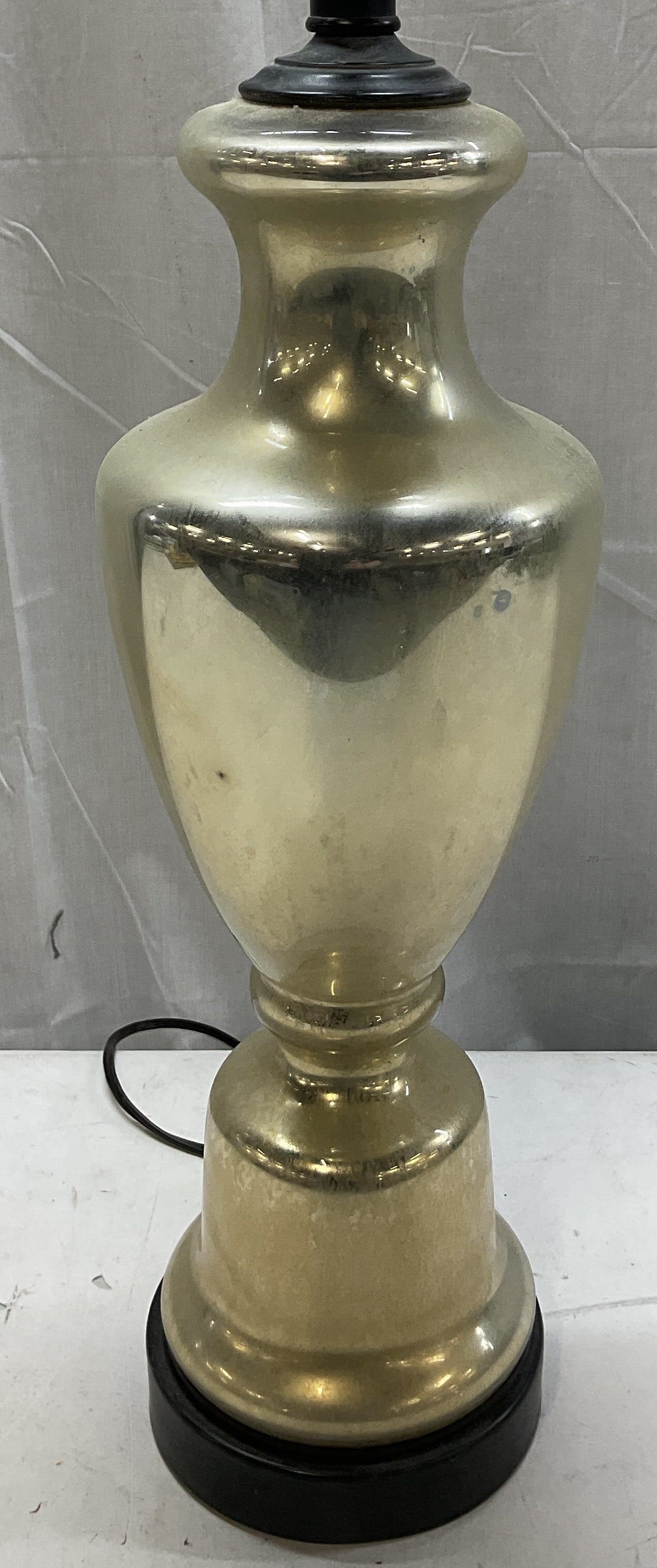 Vintage Silver Toned Glass Table Lamp: Vintage silver toned glass table lamp. Reflective appearance. Light silver toned finish. Metal base. Round pedestal base with urn shaped body. Measures ht approx 25 inches diam approx 6 inches. Not te