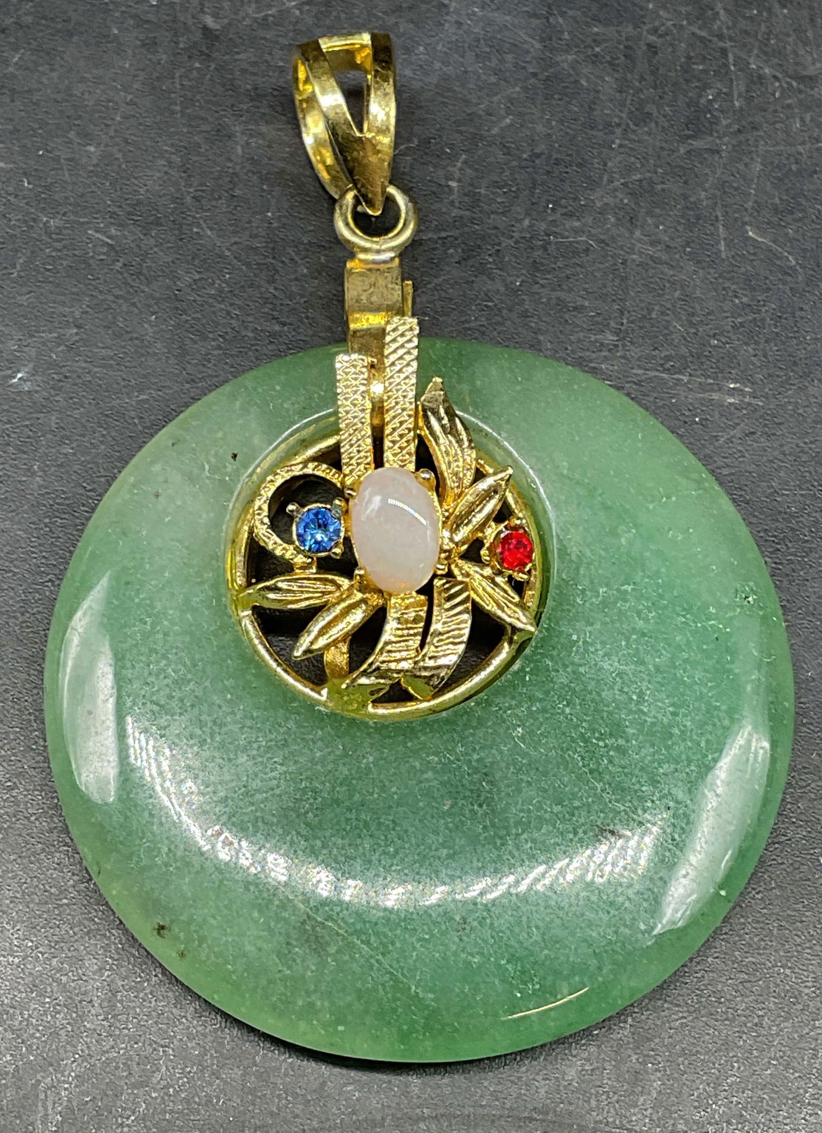 Gold Tone Round Jade & Crystal Pendant: Pendant with round polished jade, multicolor crystals and gold tone accents. Measures approx. 1 5/8 inches wide. Some scratching. Jewelry, estate jewelry, costume jewelry, cocktail jewelry,