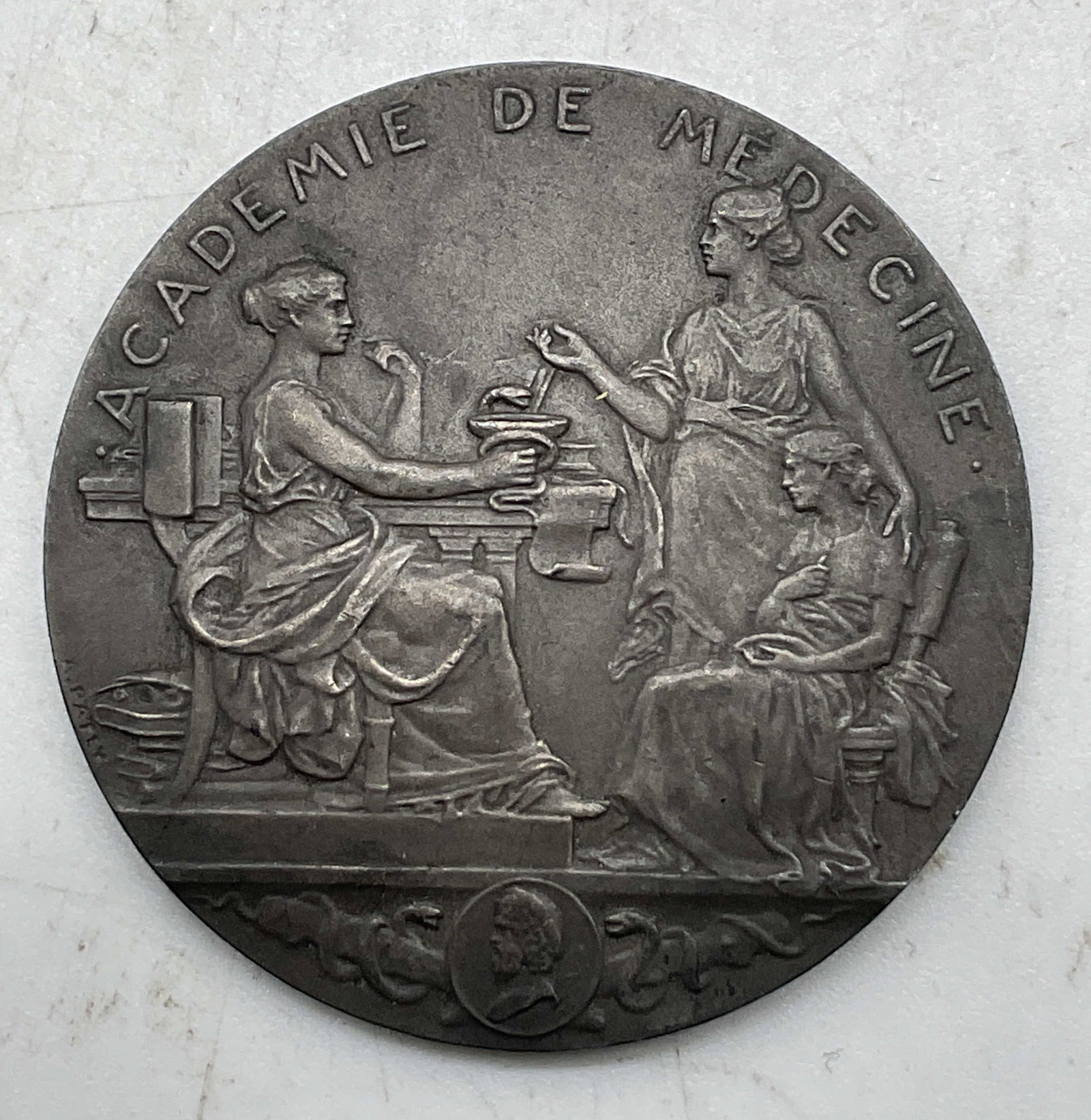 1952 French Medal Academie De Medecine+: French silver toned medal. Reads Academie De Medecine M. Evans 1952. Other side reads Academie De Medecine. Circular shape. Features embossed imagery of figures interacting. Detailed features and text