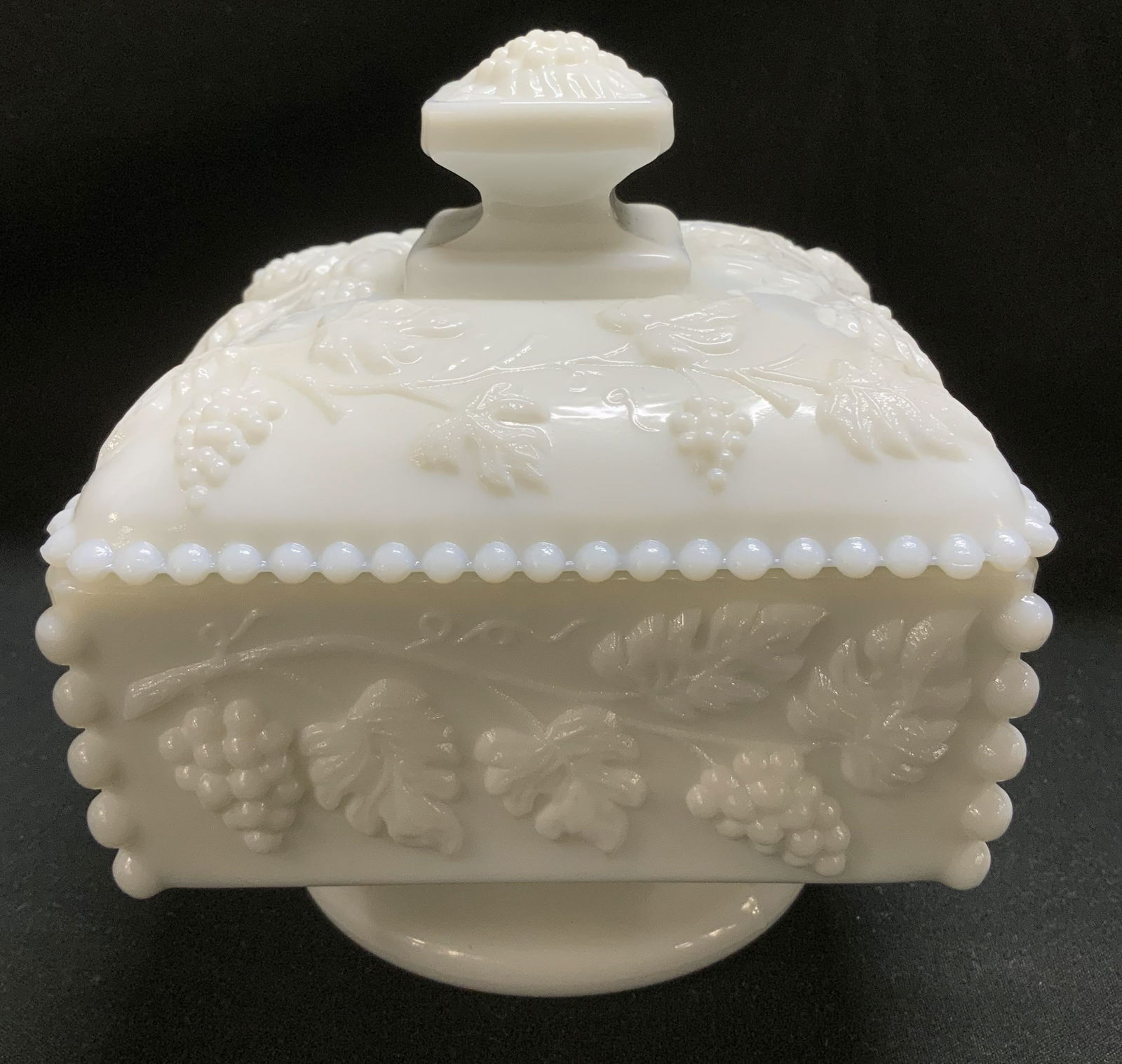Vtg Westmoreland Milk Glass Lidded Dish: Vintage Westmoreland milk glass honey dish featuring a raised grape pattern. Beaded border. Signed & marked on underside. Visible W. Surface wear consistent to age, use & exposure. Measurements: lengt