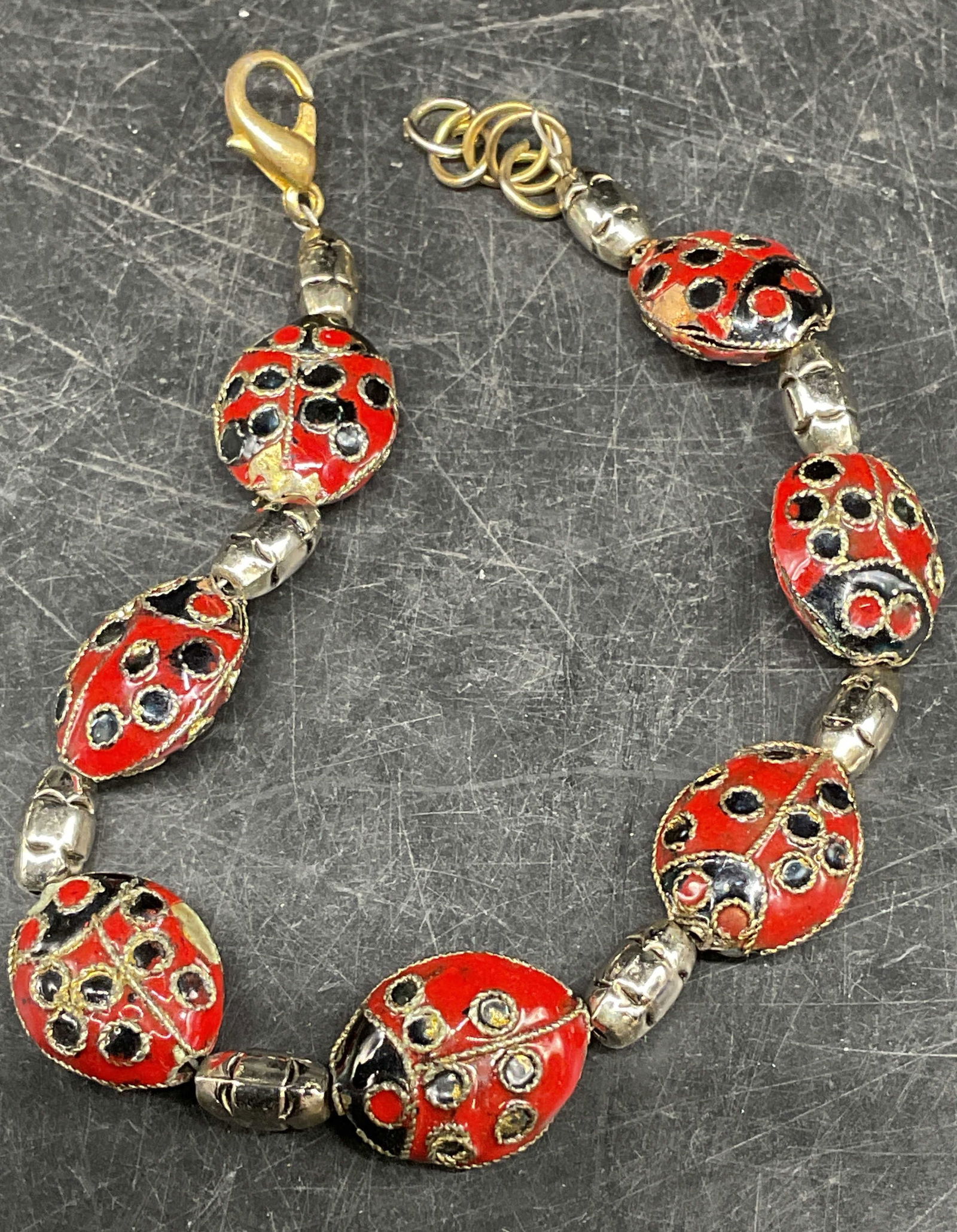 Vintage Silver Tn Enamel Ladybug Bracelet: Vintage silver tone bracelet with enameled ladybug beads. Measures approx. 7.25 inches long. Some scratching and loss to enamel. Jewelry, estate jewelry, costume jewelry, cocktail jewelry, fashion jew