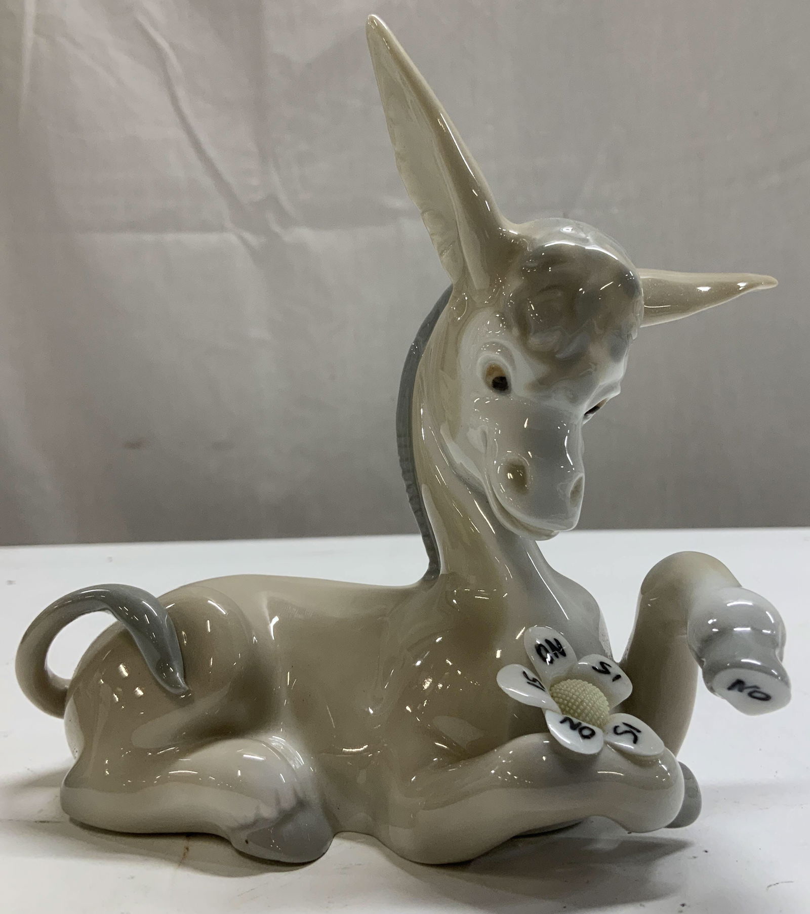 Lladro Hand Made Donkey in Love Porc Fig SPAIN: Lladro porcelain figurine depicts a donkey playing the love me, love me not game. Glossy finish. Under hoof reads, No. Signed & marked on underside. Reads, LLADRO HAND MADE IN SPAIN. Surface wear cons