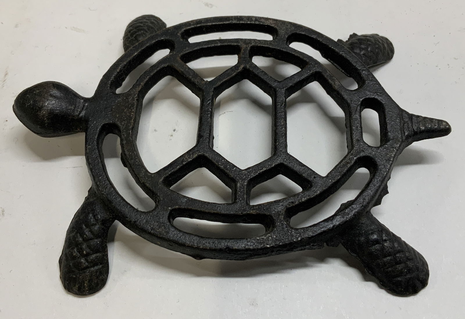 Vintage Cast Iron Turtle Trivet: Vintage cast iron trivet shaped like a turtle with a hexagonal pattern shell. Black toned. No visible signature or markings. Surface wear consistent to age, use & exposure. Measurements: length