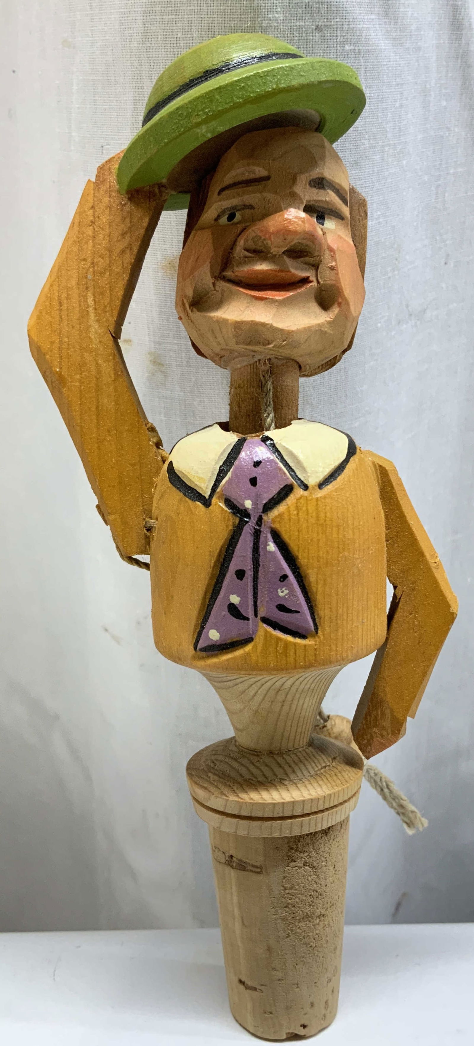 Vtg Hand Carved Wooden Fig Bottle Stopper: Vintage hand carved wooden bottle stopper featuring a pull string on back causing figure to tip its hat. Hand painted details. Shades of green, yellow, white, purple. Surface wear consistent to