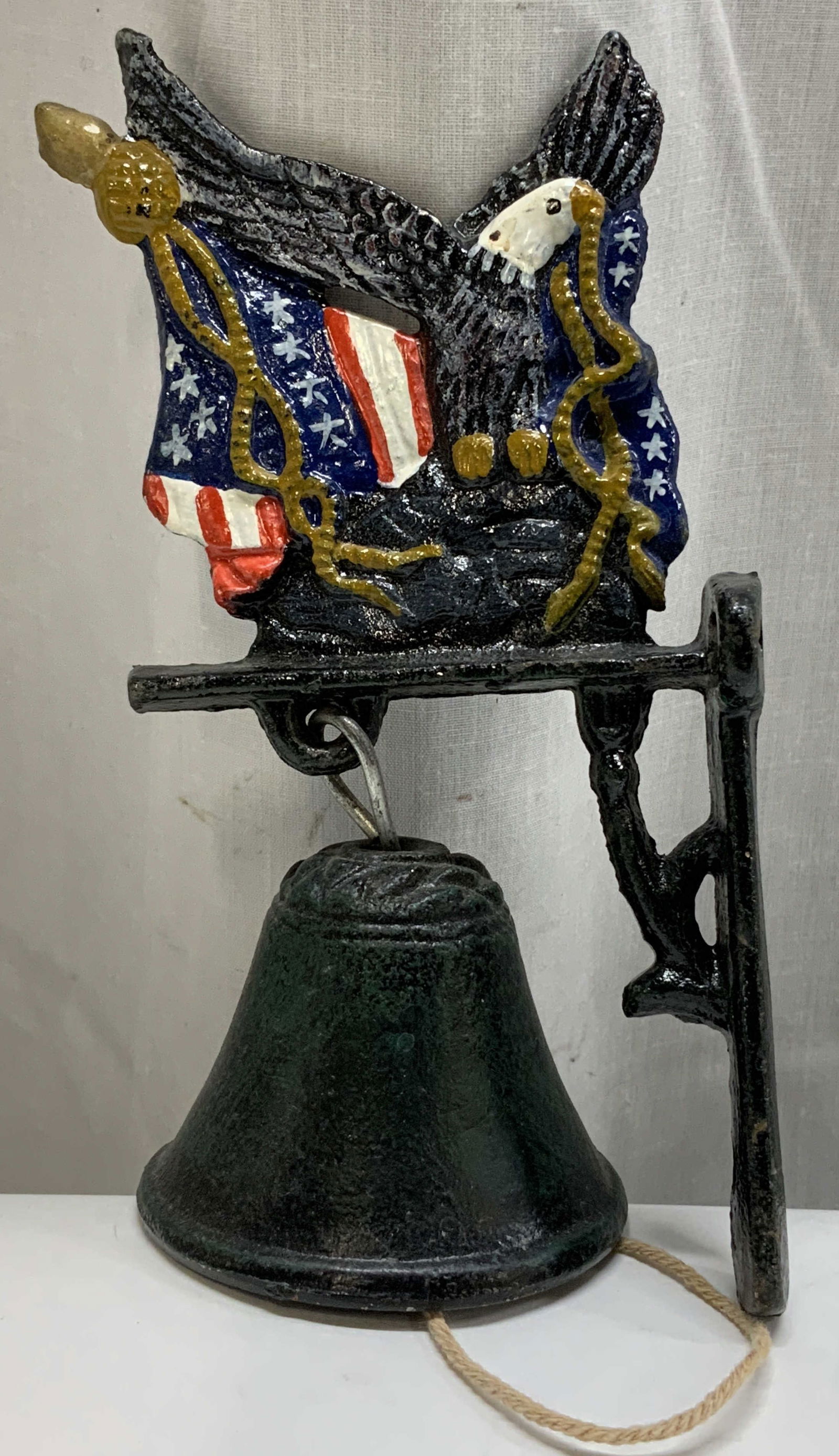 Vtg Cast Iron Patriotic Hanging Doorbell: Vintage cast iron hanging doorbell features a patriotic eagle & American flag. Hand painted details. Bell attached with string. No visible signature or markings. Surface wear consistent to age,