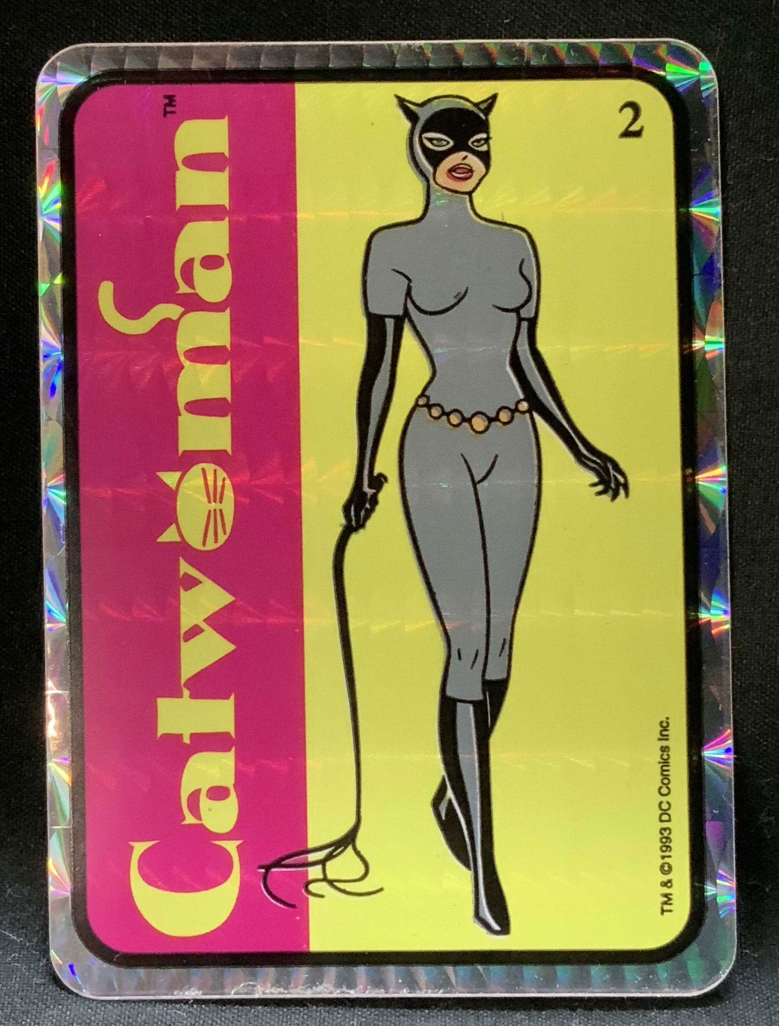 1993 DC Comics Catwoman Holographic Sticker: 1993 collectible sticker featuring Catwoman, with a holographic foil border. Catwoman, numbered 2. Pink & yellow background. Signed & marked. Reads, TM & 1993 DC COMIC. Surface wear consistent to