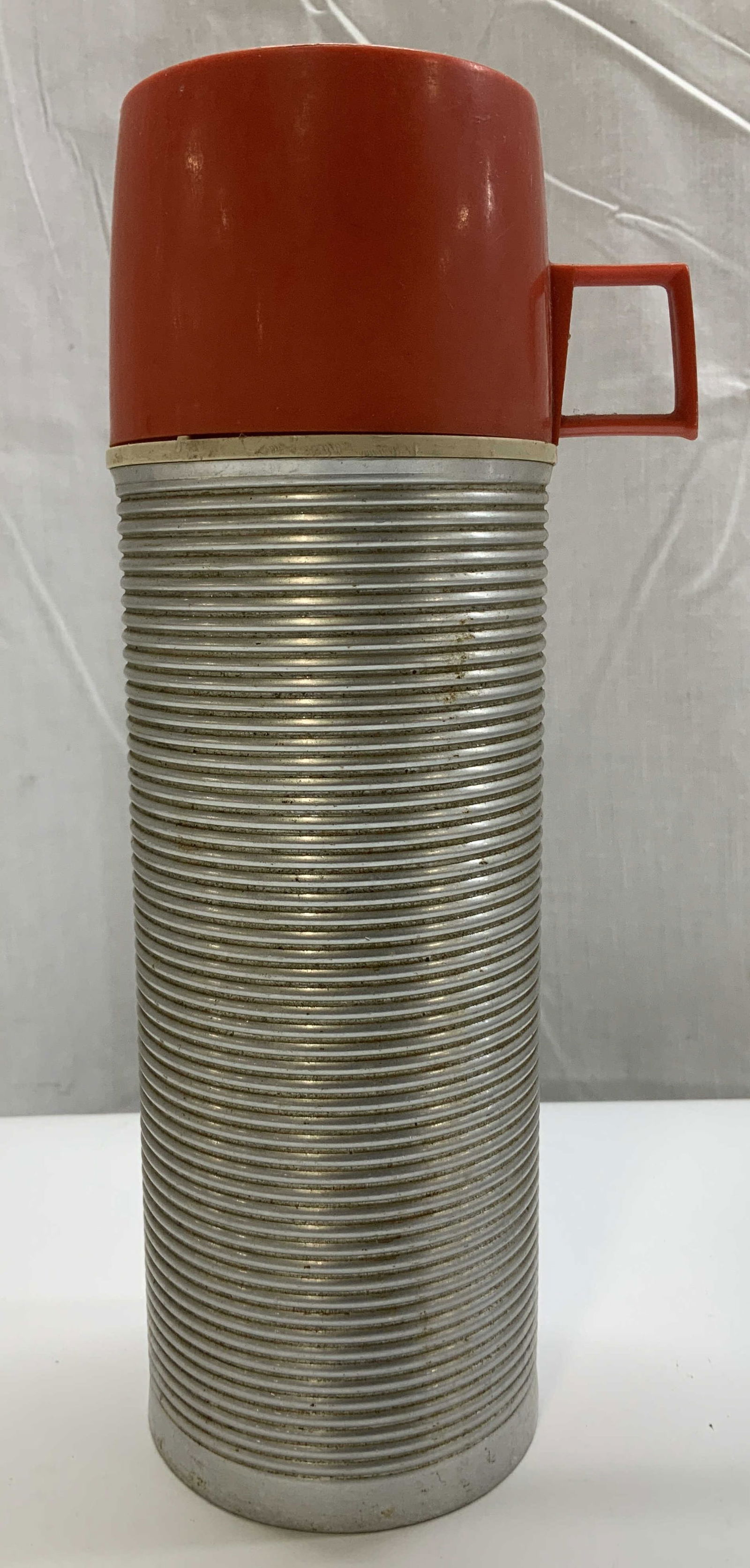 Vtg Thermos King Seely Vacuum Bottle USA: Vintage thermos king seely vacuum bottle, featuring a ribbed aluminum body & red plastic cup lid. Signed & marked on underside. Reads, THERMOS DIVISON KING SEELY. Surface wear consistent to age, use &