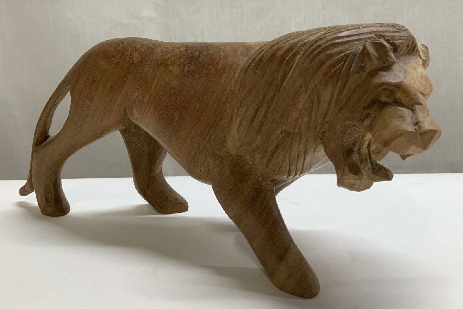 Vtg Hand Carved Wooden Lion Figurine: Vintage wooden lion figurine featuring detailed carvings of face. Brown toned. Fig is in a walking pose. Surface wear consistent to age, use & exposure. Measurements: length 9in x width 2.5in x