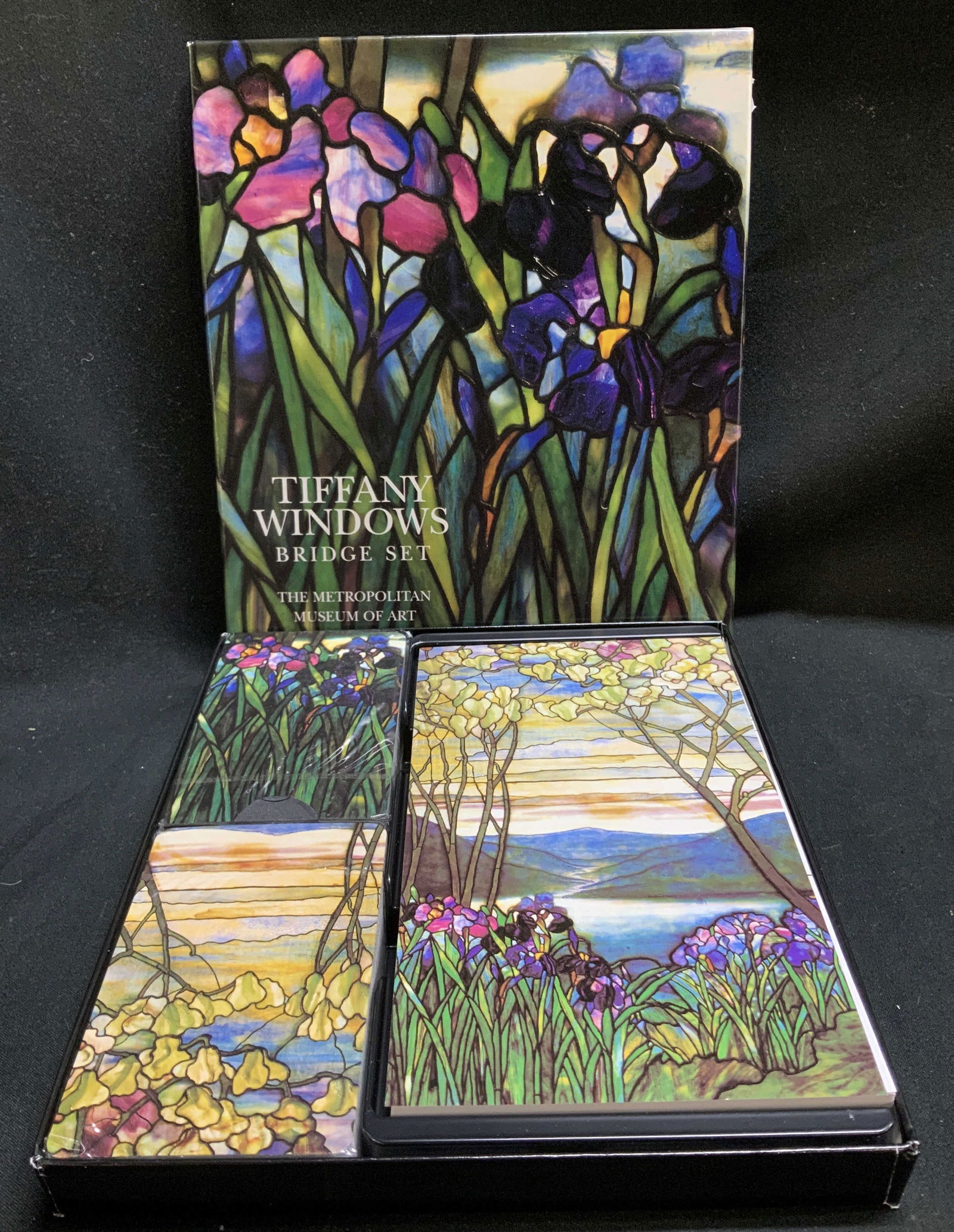 Metropolitan Museum Tiffany Windows Bridge Set NIP: Tiffany Windows bridge set is new in plastic. Features 2 sealed deck of card & booklet for contract bridge score. Comes with original box. Sold as is. Signed & marked. Reads, Tiffany Windows. Bridge S