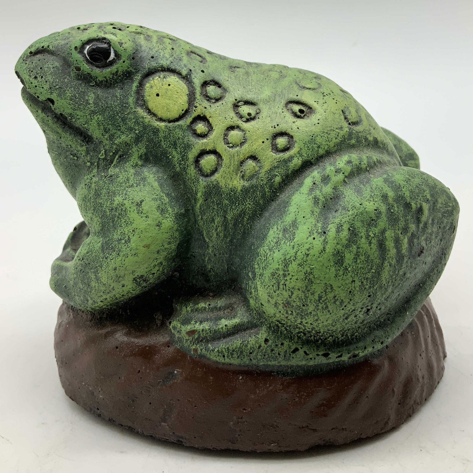 Vtg Sitting Frog Composite Figurine: Vintage figurine depicting a green frog sitting on a round brown base. Detailing on frogs body. Composite material. Sold as is. Surface wear consistent to age, use & exposure. Measurements: