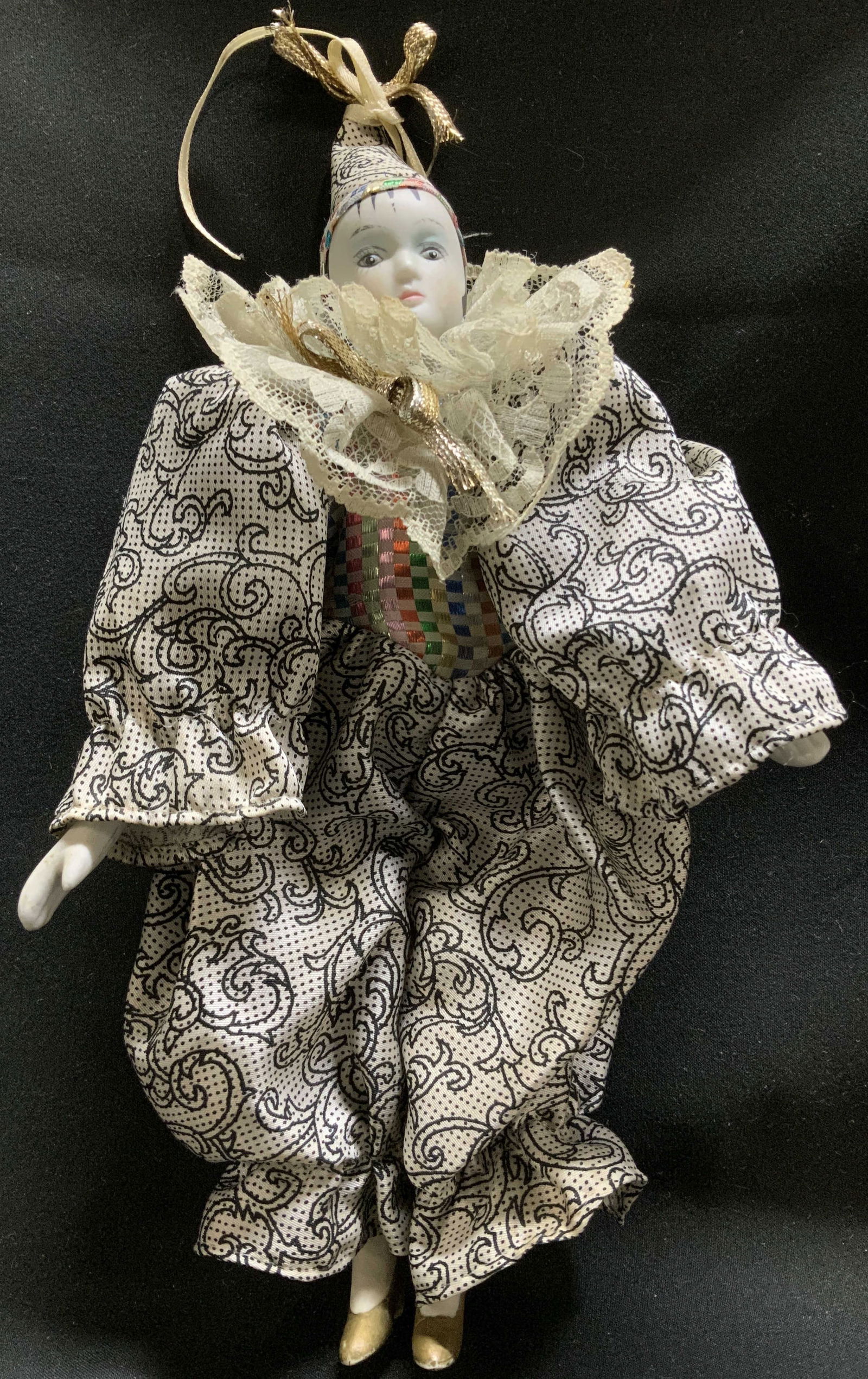 Vtg Hand Painted Porcelain Harlequin Doll: Vintage porcelain harlequin doll features hand painted details on face. Gilt heels. Doll is wearing a patterned costume with lace ruff collar & pointed hat. Property of opera singers estate from