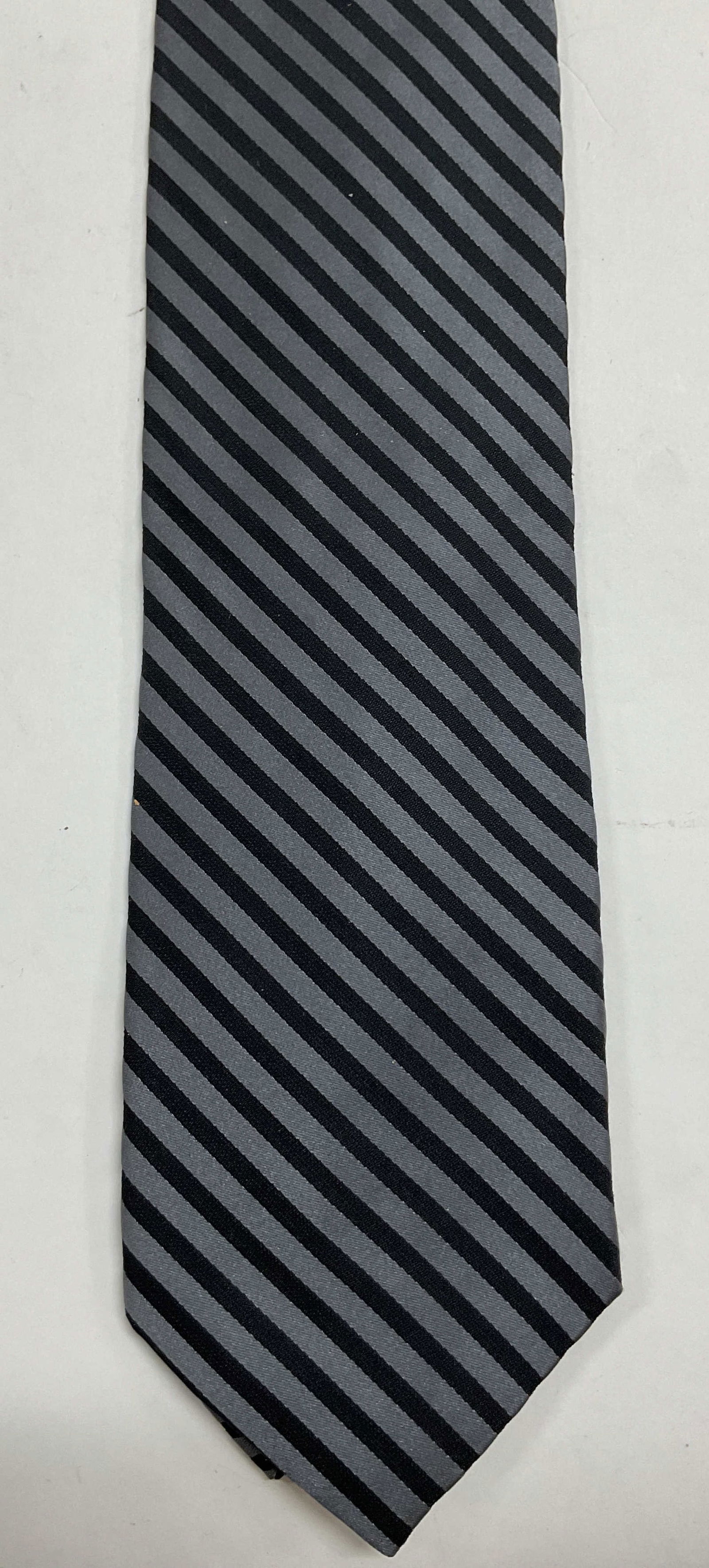 Donna Karan Striped Silk Neck Tie USA: Donna Karan striped silk neck tie. Made in USA. Silk material. Grey and black striped pattern. Measures approx 4 x 56 inches. Wear consistent with exposure. Tie, neck tie, silk tie, Donna Karan,