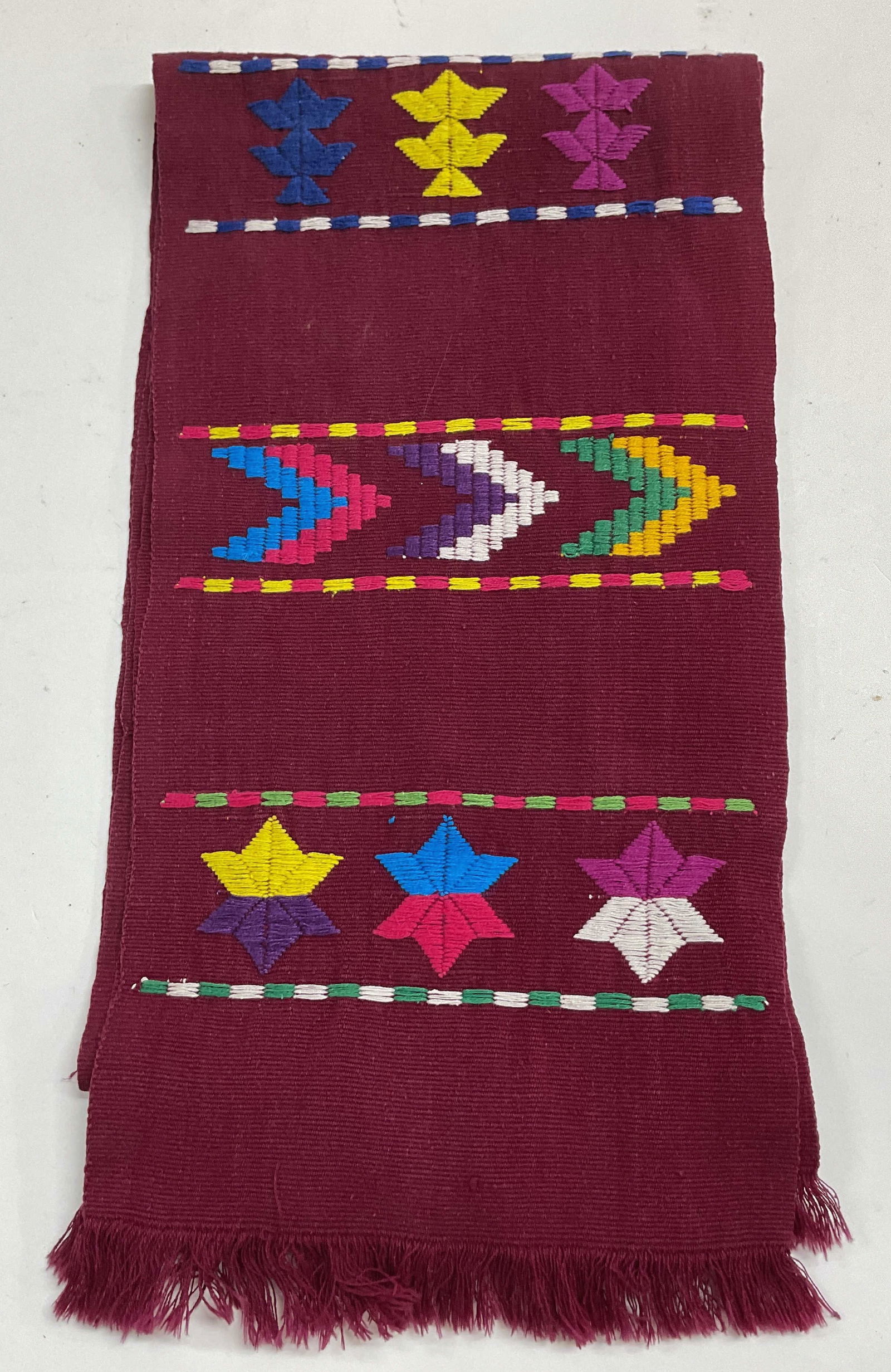 Vintage Red Wool Embroidered Fringed Scarf: Vintage red wool embroidered fringed scarf. Feels like wool. Red fringed trim. Embroidered geometric pattern in varying colors. Measures approx 8 x 55 inches. Wear consistent with exposure.