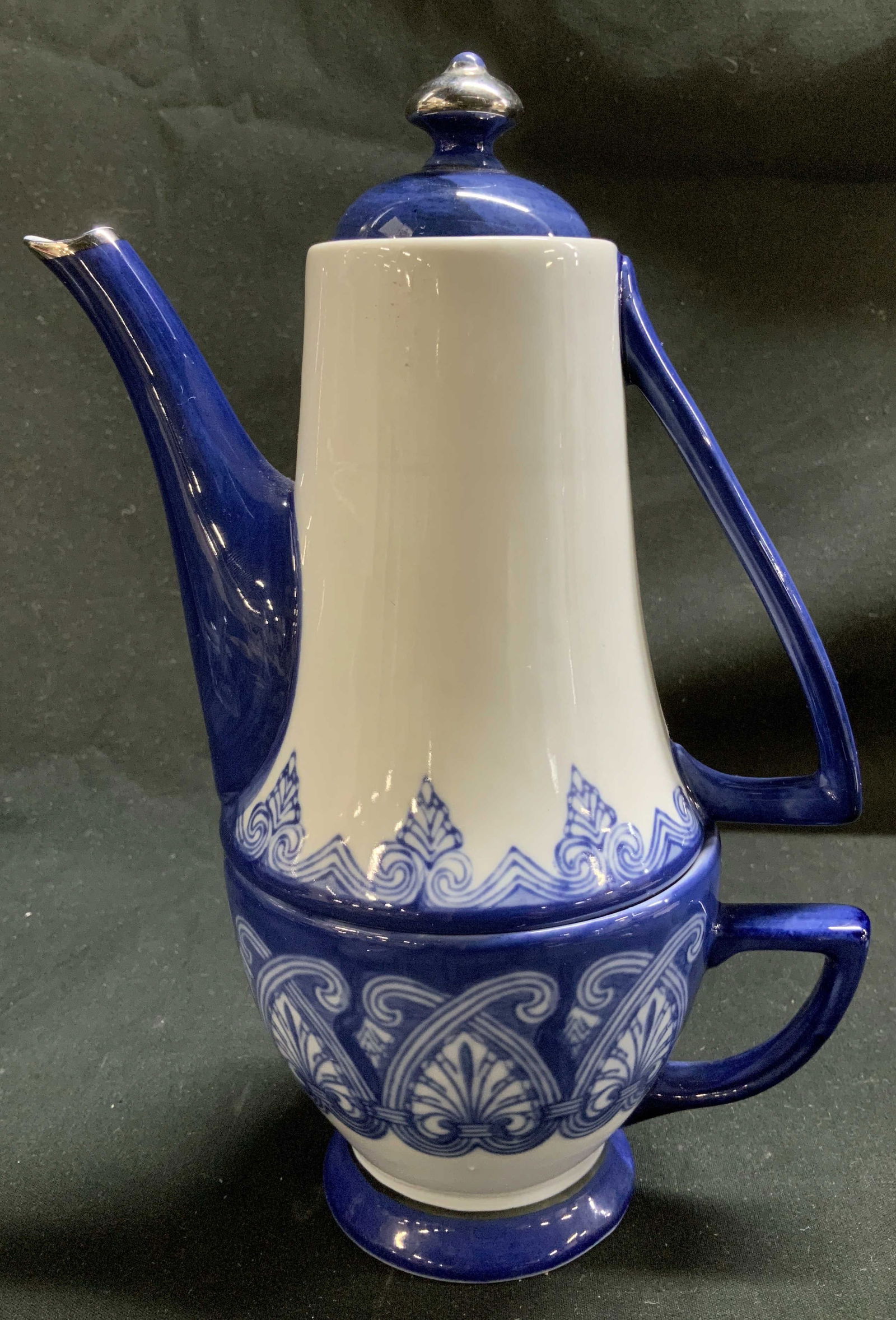 Vtg Bombay Porc Stackable Teapot & Teacup Set: Vintage Bombay blue & white porcelain stackable teapot & tea cup set. Features teapot at top & tea cup at base. Glossy finish. Signed & marked on underside. Reads, BOMBAY. Surface wear consistent