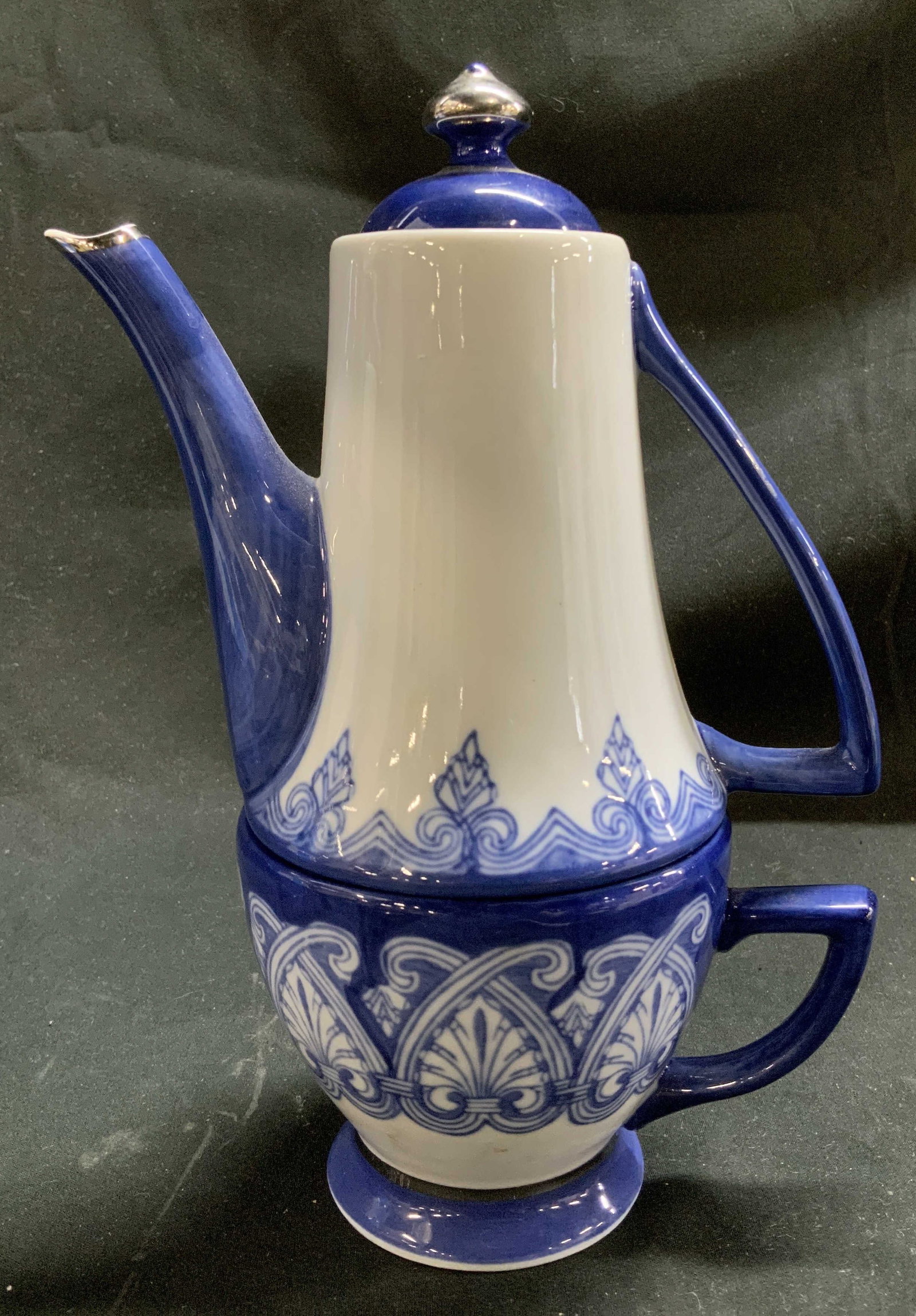 Vtg Bombay Porc Stackable Teapot & Teacup Set: Vintage Bombay blue & white porcelain stackable teapot & tea cup set. Features teapot at top & tea cup at base. Glossy finish. Signed & marked on underside. Reads, BOMBAY. Surface wear consistent to a