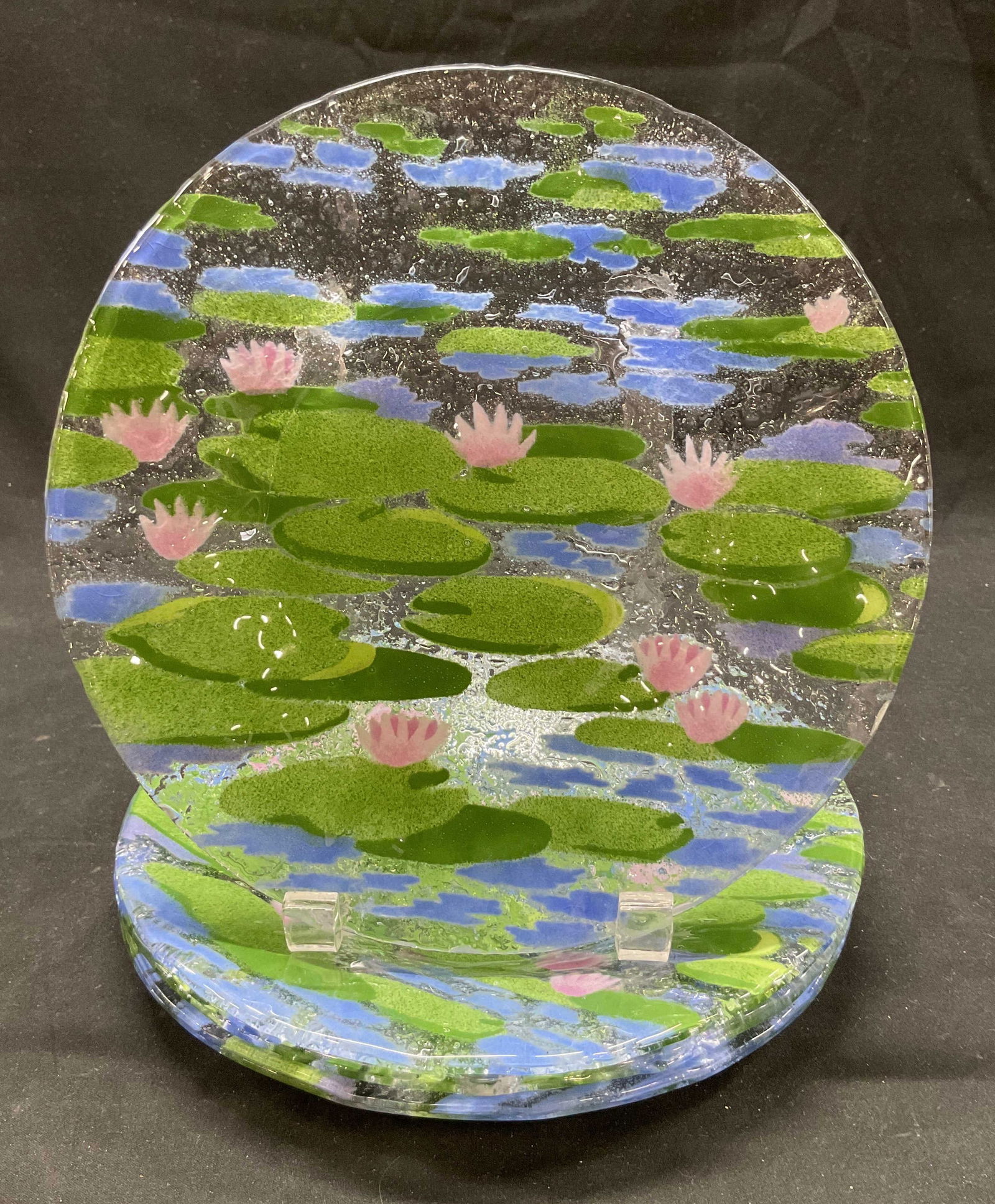 Set 4 SGND A.C. Ross Water Lily Art Glass Plates: Set of 4 A.C. Ross water lily art glass fused plates. Signed AC Ross on underside. Round plates. Water lily pond design in green, pink, and blue. Abstract shapes. Measures approx 8.5 inches in