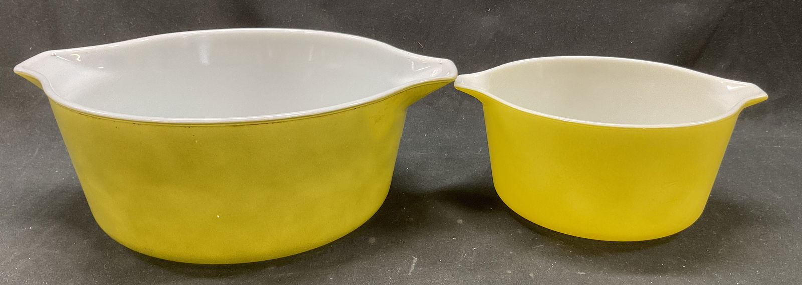 Lot 2 Pyrex Glass Casserole Dishes USA: Lot of 2 Pyrex glass casserole dishes. Marked on underside, reads Pyrex Made In USA Ovenware. Round dishes with handles. Greenish yellow color. Largest measures approx 9 x 11 x 4 inches. Wear to