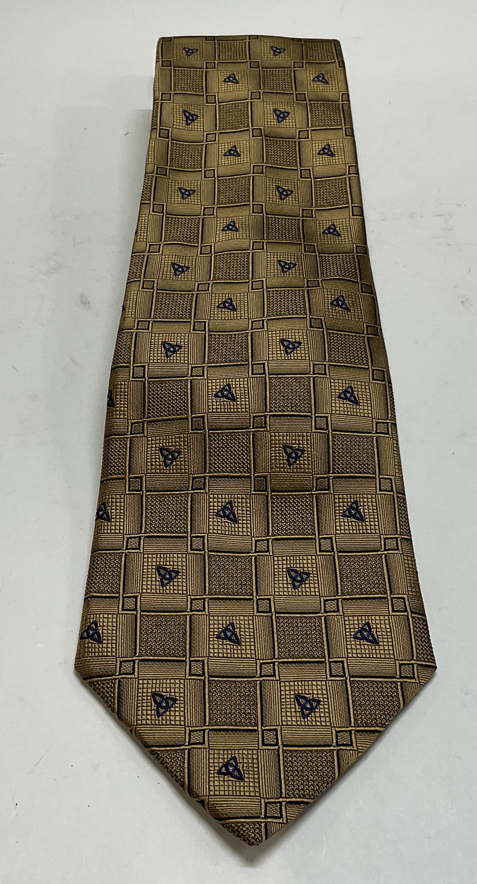 Patrick Francis Silk Tie Ireland: Patrick Francis Pure Silk Tie. Ireland. Features a blue geometric pattern on gold. Condition consistent with exposure. Measures approximately 62 x 3 11/16 inches. Patrick Francis, Pure Silk Tie, Irela