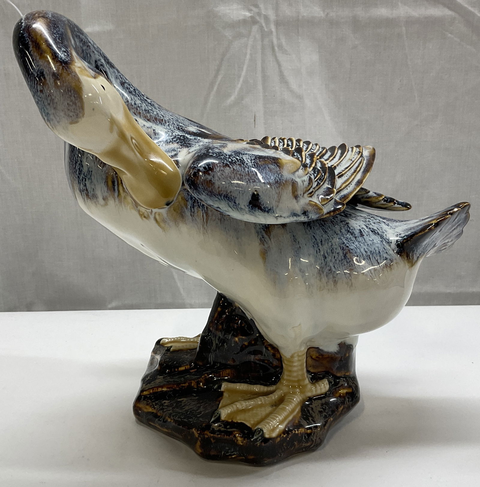 Mid-Century Modern Mallard Duck Figurine: Mid-Century Modern Mallard Duck Figurine. Possibly made of ceramic or pottery. Blue-speckled and brown swirls pattern. Measures approximately 4 3/4 x 8 inches. Chips are present on edge of wing and on