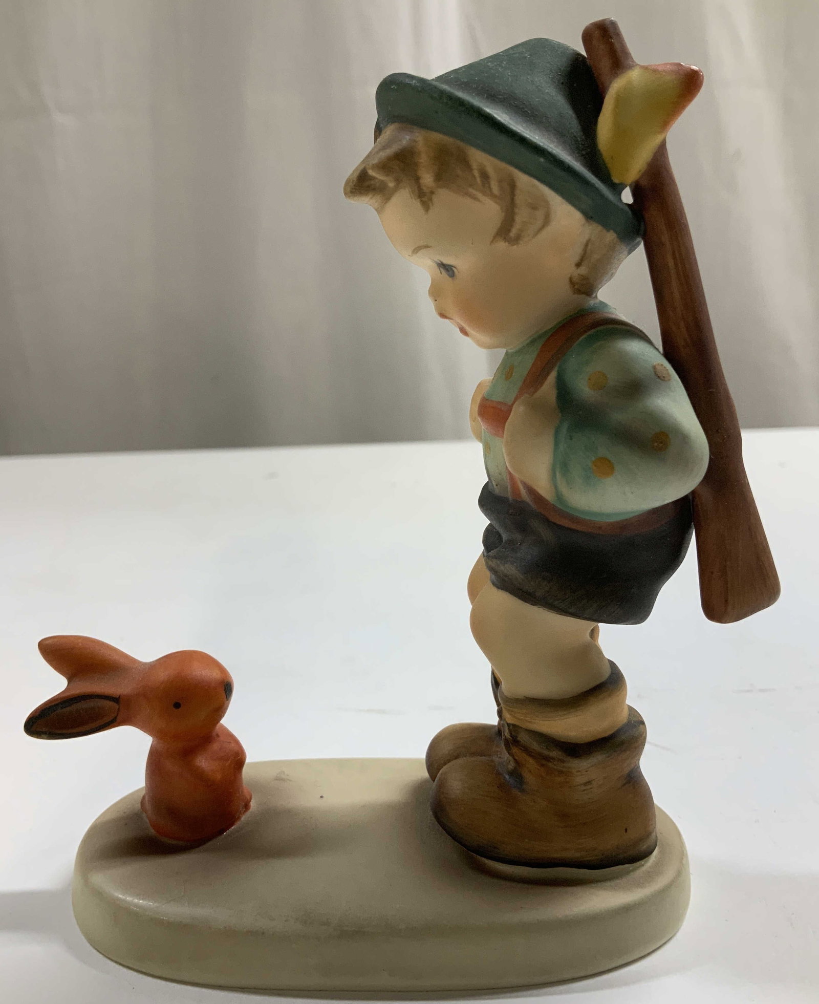 Vtg Goebel Sensitive Hunter Figurine W.GERMANY: Vintage Goebel figurine depicting a young boy in Bavarian style attire with a small orange rabbit. Signed & marked on underside. Reads, GOEBEL W.GERMANY. Surface wear consistent to age, use & exposure