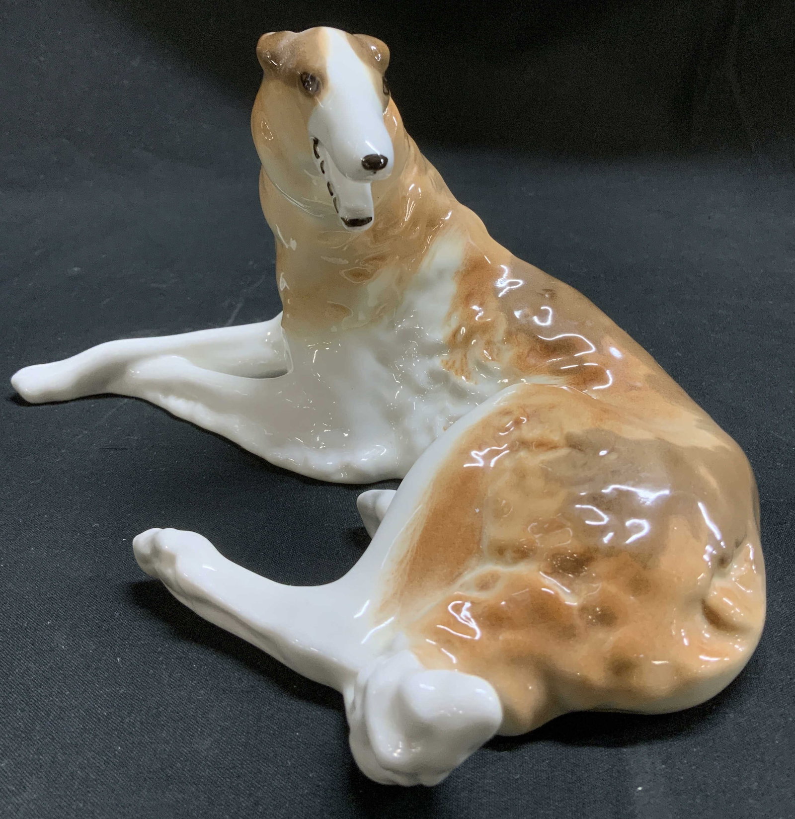Sgnd Hand Painted Porcelain Dog Fig RUSSIA: Porcelain dog features hand painted details in brown & white tones. Glossy finish. Dog is in a laying position. Signed & marked on underside. Visible mark & MADE IN RUSSIA. Surface wear consistent to 