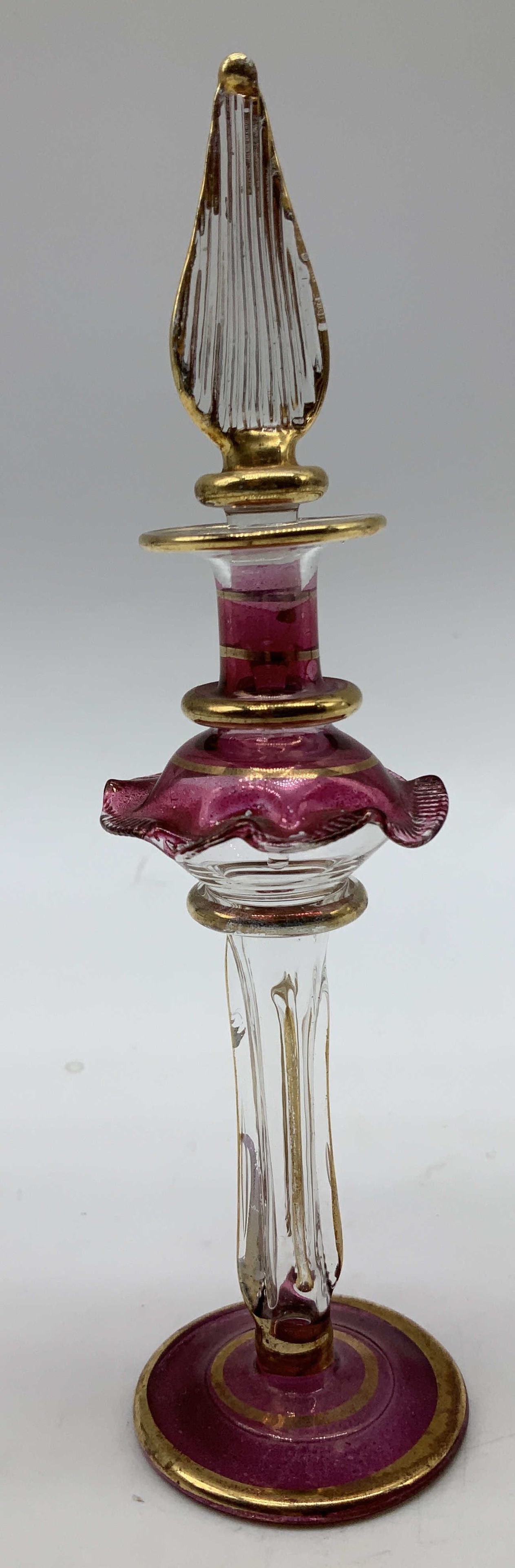 Vtg Hand Blown Purple & Gilt Perfume Bottle: Vintage hand blown perfume bottle featuring purple & gilt accents. Ruffled edge & pointed finial. Lid appears to be stuck. Sold as is. Surface wear consistent to age, use & exposure. Measurements: len