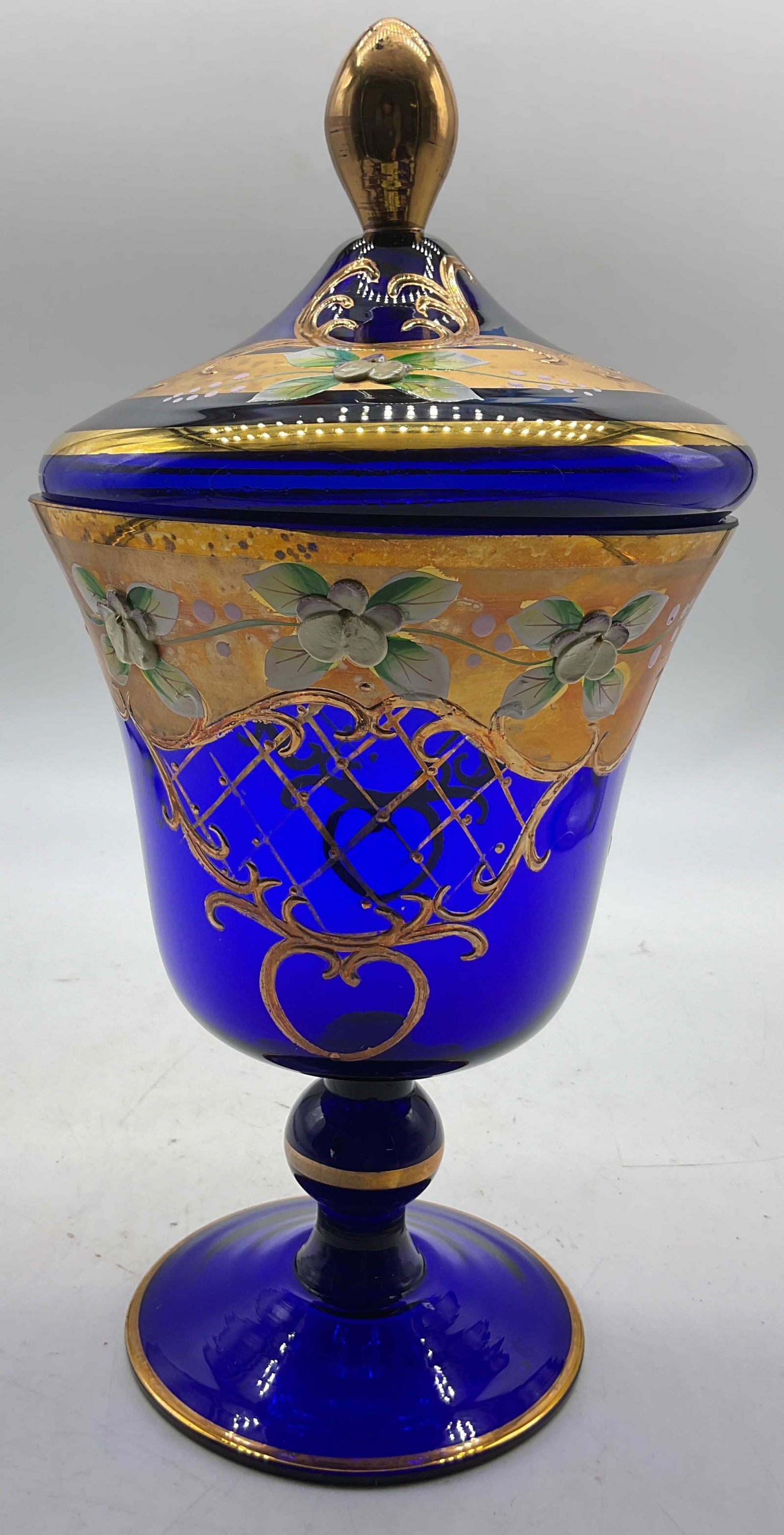 Vtg Cobalt Blue Glass Pedestal Candy Jar W Lid: Vintage hand painted cobalt blue glass pedestal lidded candy jar. Round pedestal base with ball design stem. Round wide rim and body. Gilt diamond pattern and scroll accents. Hand painted floral motif