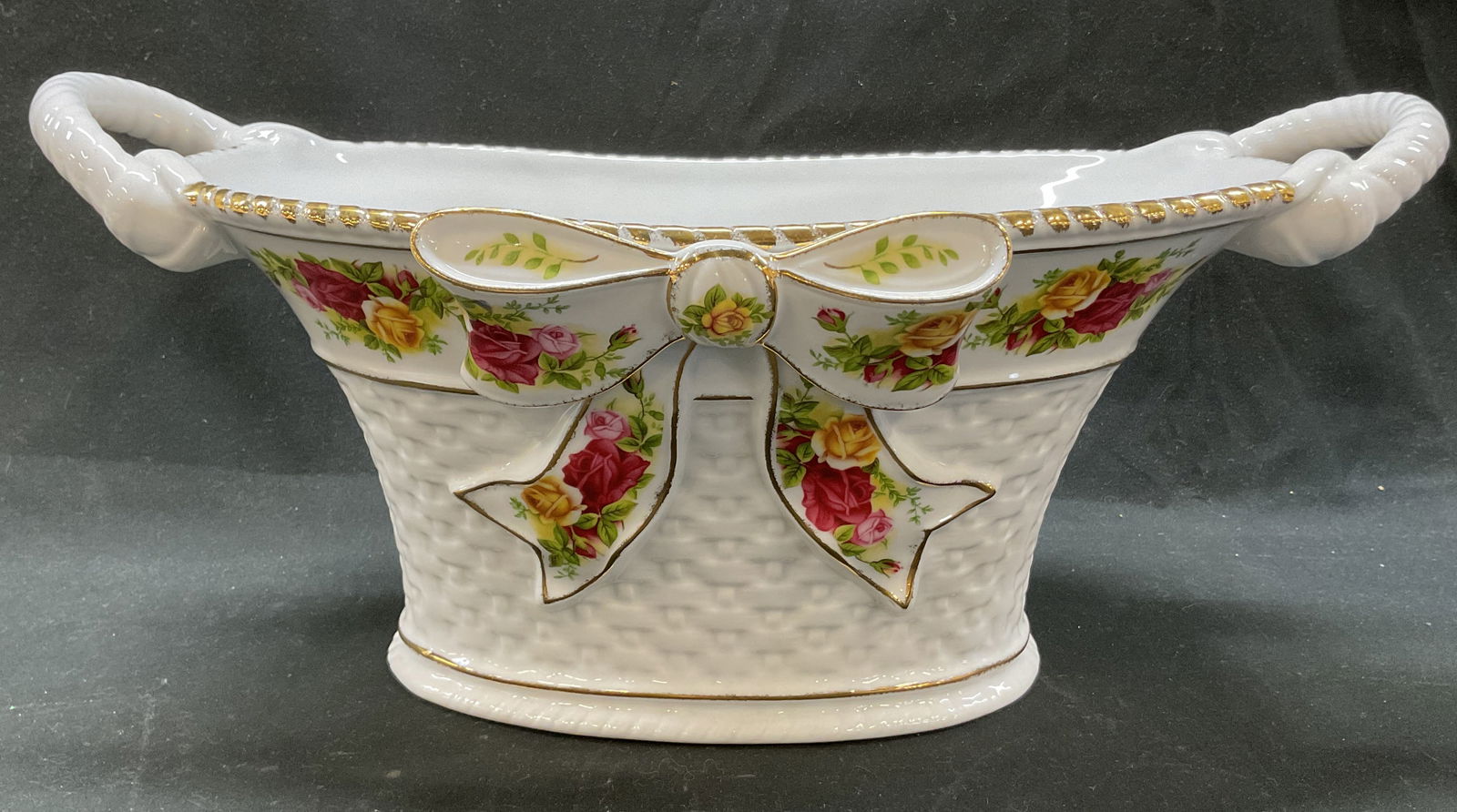 1962 Royal Albert Old Country Roses Center Basket: Royal Albert Old Country Roses porcelain centerpiece basket. Marked on underside, reads Old Country Roses 1962 Royal Albert Ltd. Round basket with ribbed handles. Gilt ribbed edge. Basket weave