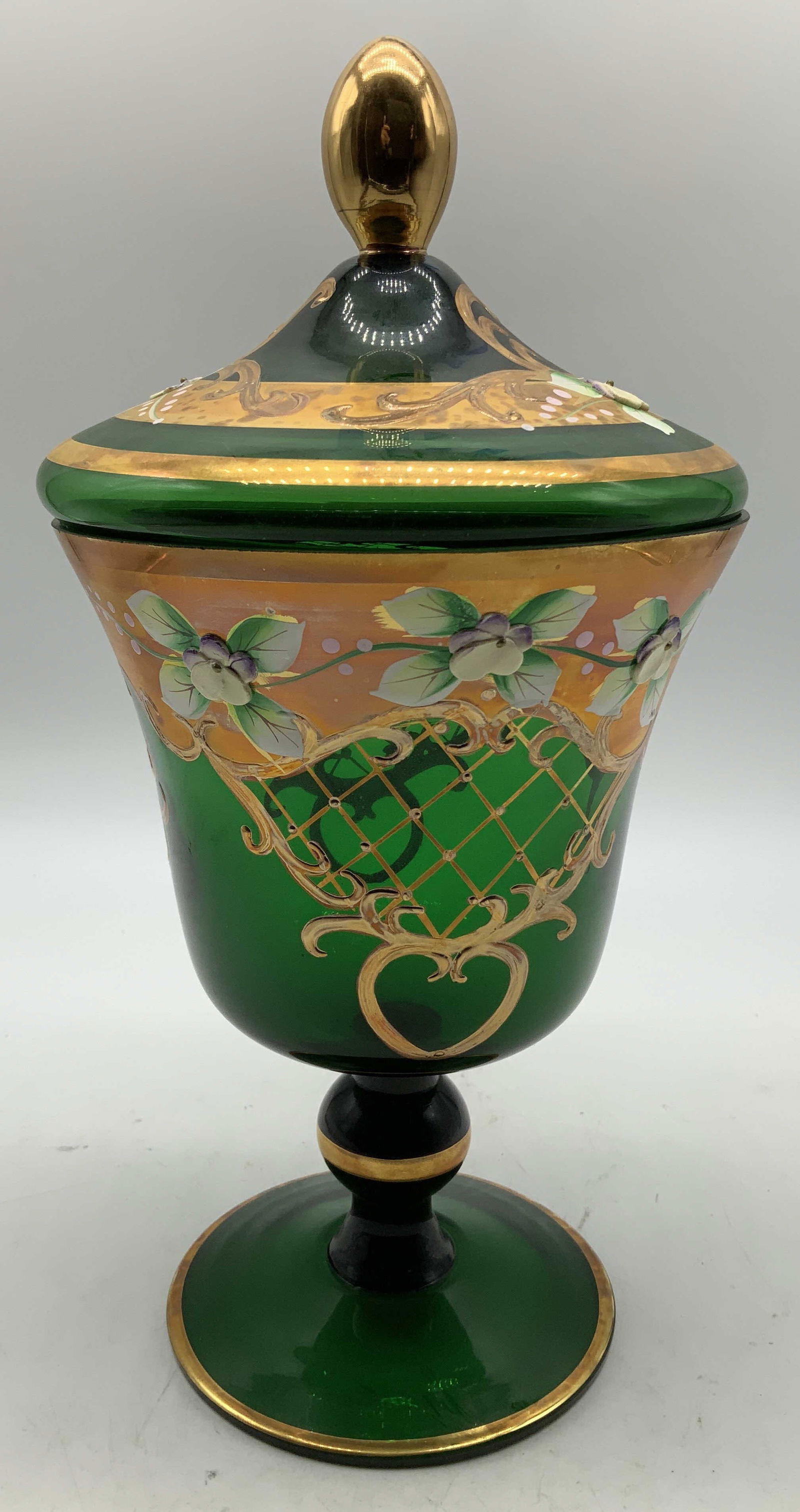 Vtg Hand Painted Floral Motif Glass Compote: Vintage green glass compote features hand painted floral motifs on body & lid. Extensive gilt accents. Pointed gilt finial. Round base. Surface wear consistent to age, use & exposure. No visible