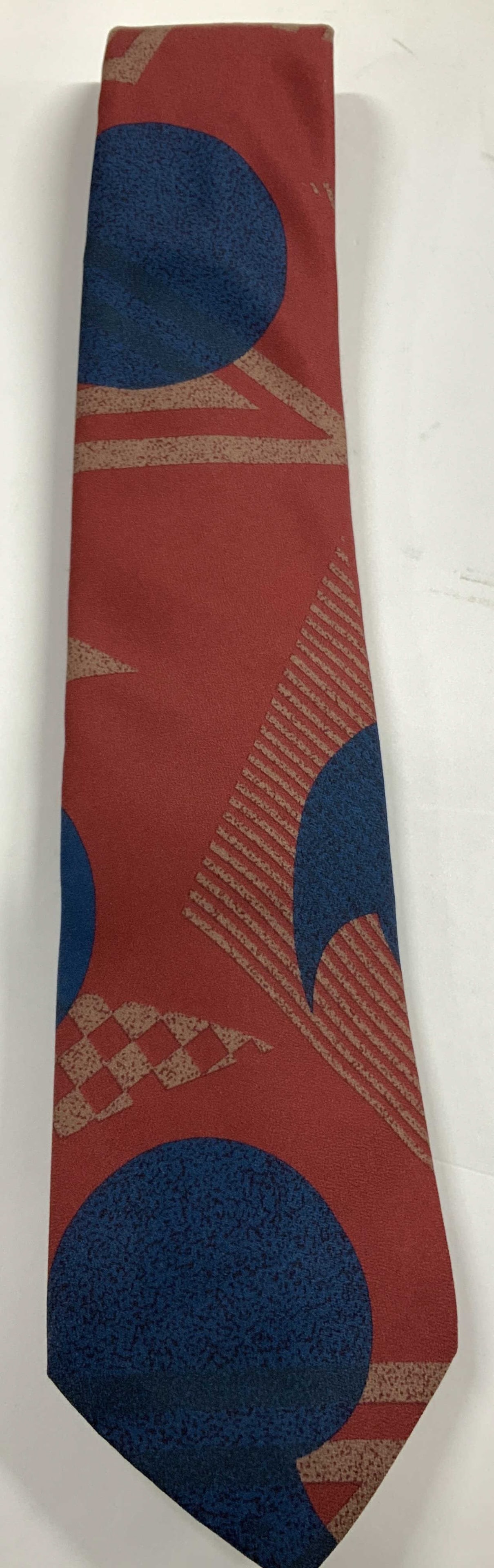 Italian Hand Made Abstract Silk Necktie: Necktie is 100% silk material. Features an abstract style pattern. Shades of red & blue. Signed & marked. Reads, ITALIAN ALL SILK HAND MADE. Surface wear consistent to age, use & exposure. Measurement