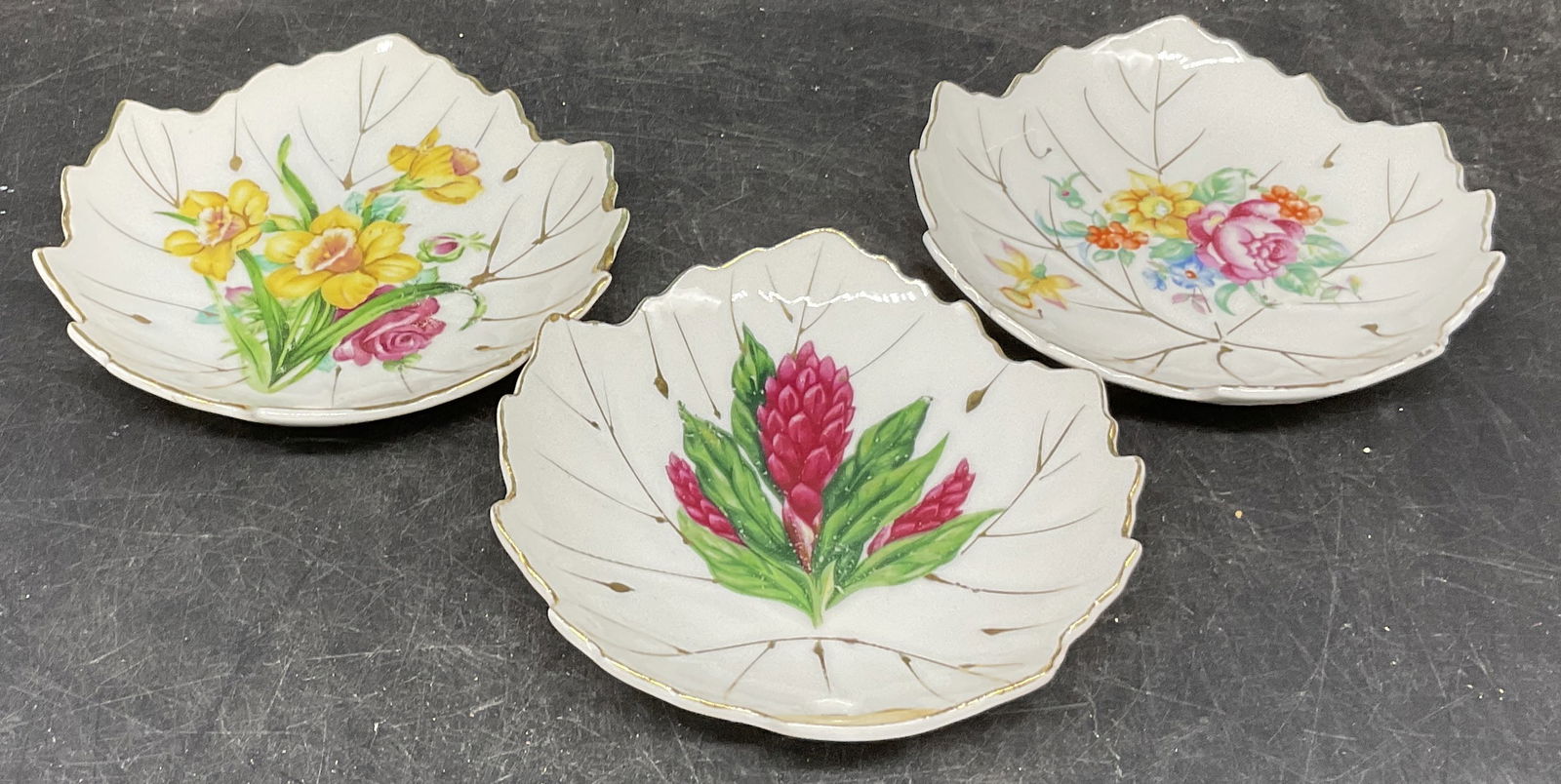 Set of 3 Nasco Japan Hand-Painted Leaf Dishes: Lot of 3 Nasco Japan Hand-Painted Leaf Dishes. Various florals painted on the interior. Gold colored trim on the edges and interor. Possibly ceramic or porcelain. Each measures approximately 4 3/4in H