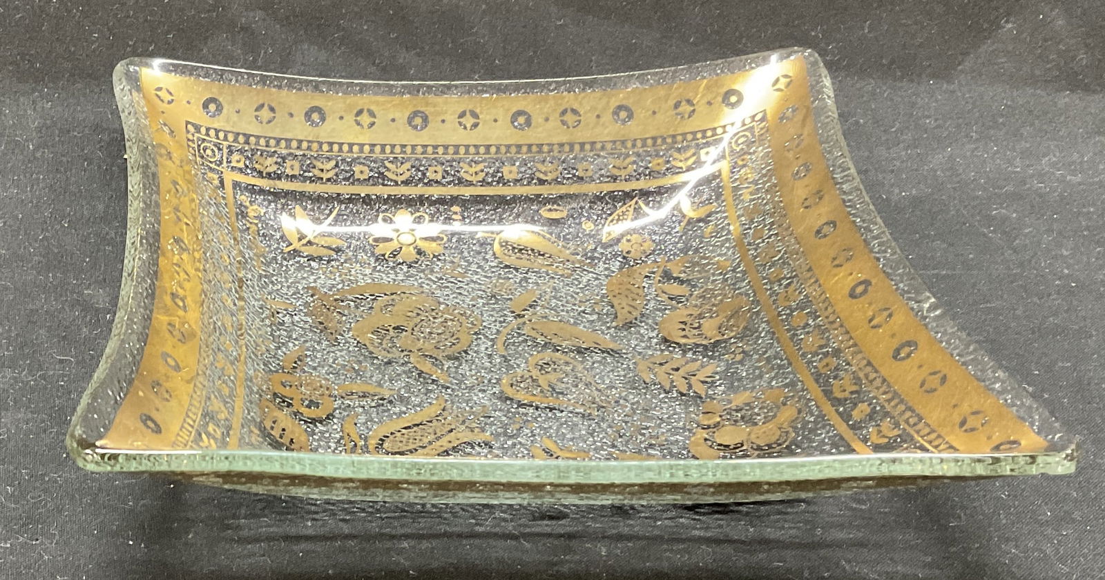 Gilded Floral Glass Dish: Gilded Floral Rectangular Glass Dish. Flowers are etched in gold-colored design. Possibly vintage. No visible markings. In the style of designer Georges Briard. Measures approximately 1in H x 6 1/8in