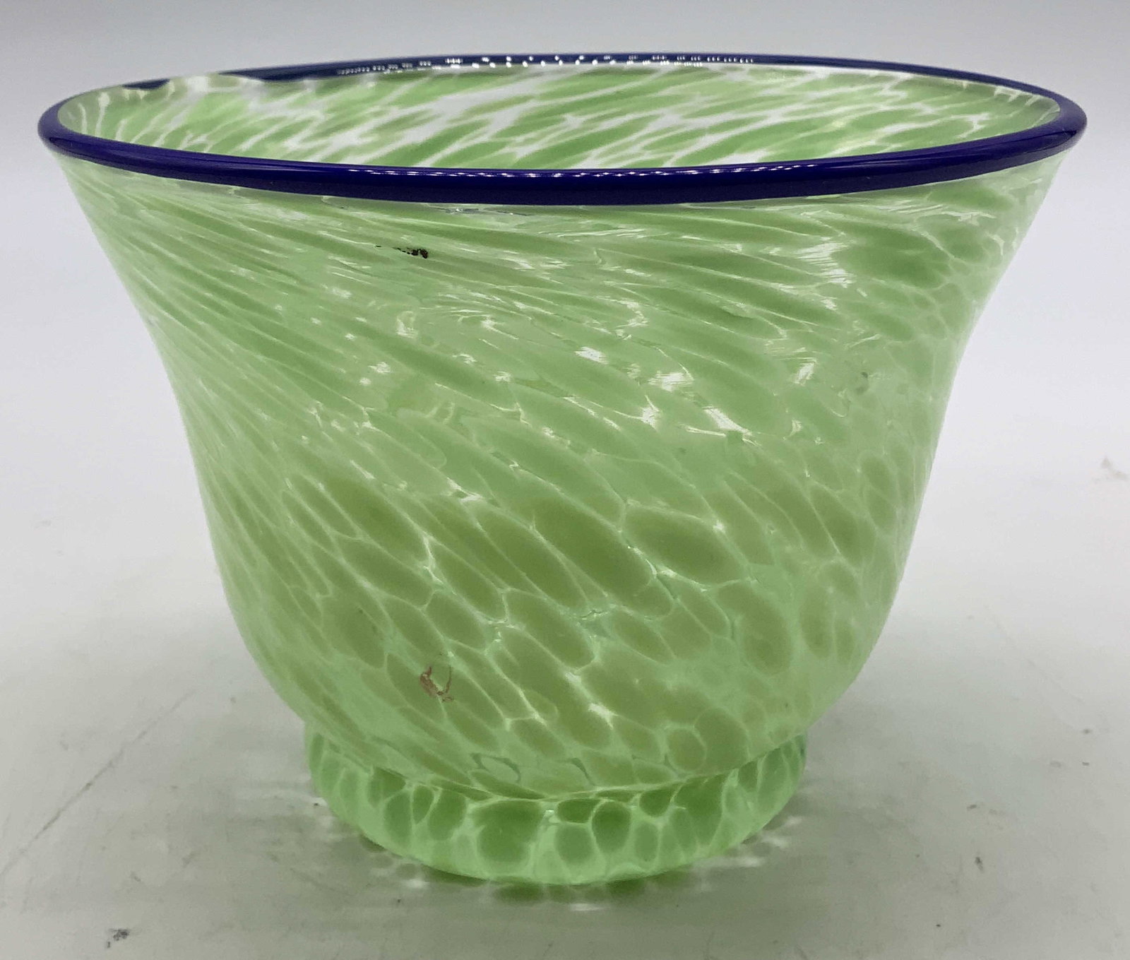 Green & Blue Art Glass Vase: Art glass vase features a green spotted pattern on body & blue rim. Surface wear consistent to age, use & exposure. Measurements: length 4.7in x width 4.7in x height 3.5in. Green & blue art glass vase