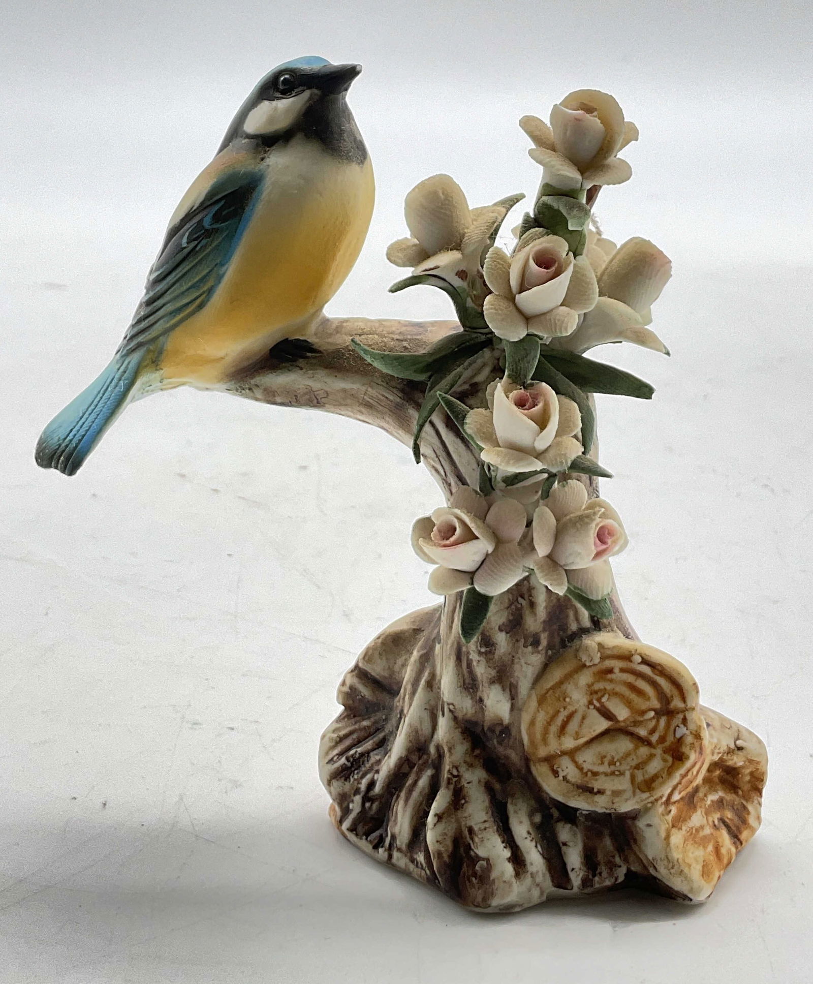 Capodimonte Global Art Porcelain Bird Figure Italy: Capodimonte Global Art porcelain bird figure. Marked on underside, reads Capodimonte Global Art Italy. Bird figure perched on branches adorned with floral motifs. Hand painted in varying colors. Detai