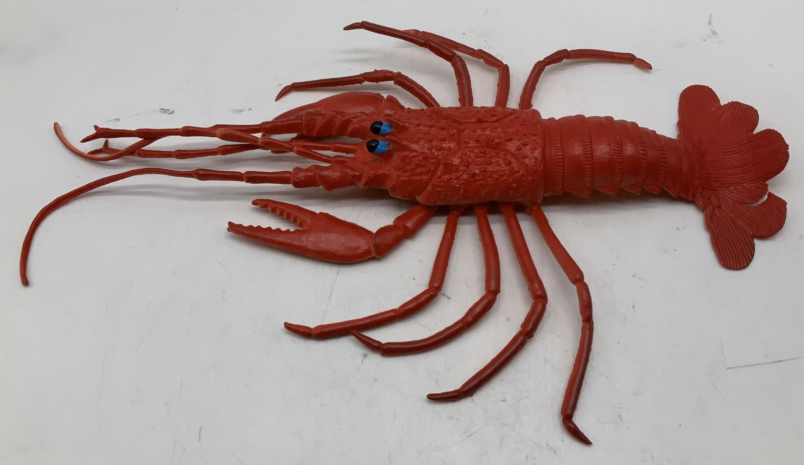 Vntg Rubber Lobster Figurine 12.5in: Vintage lobster figurine is red toned & features blue with black eyes. Rubber material. No visible signature or markings. Surface wear consistent to age, use & exposure. Measurements: length