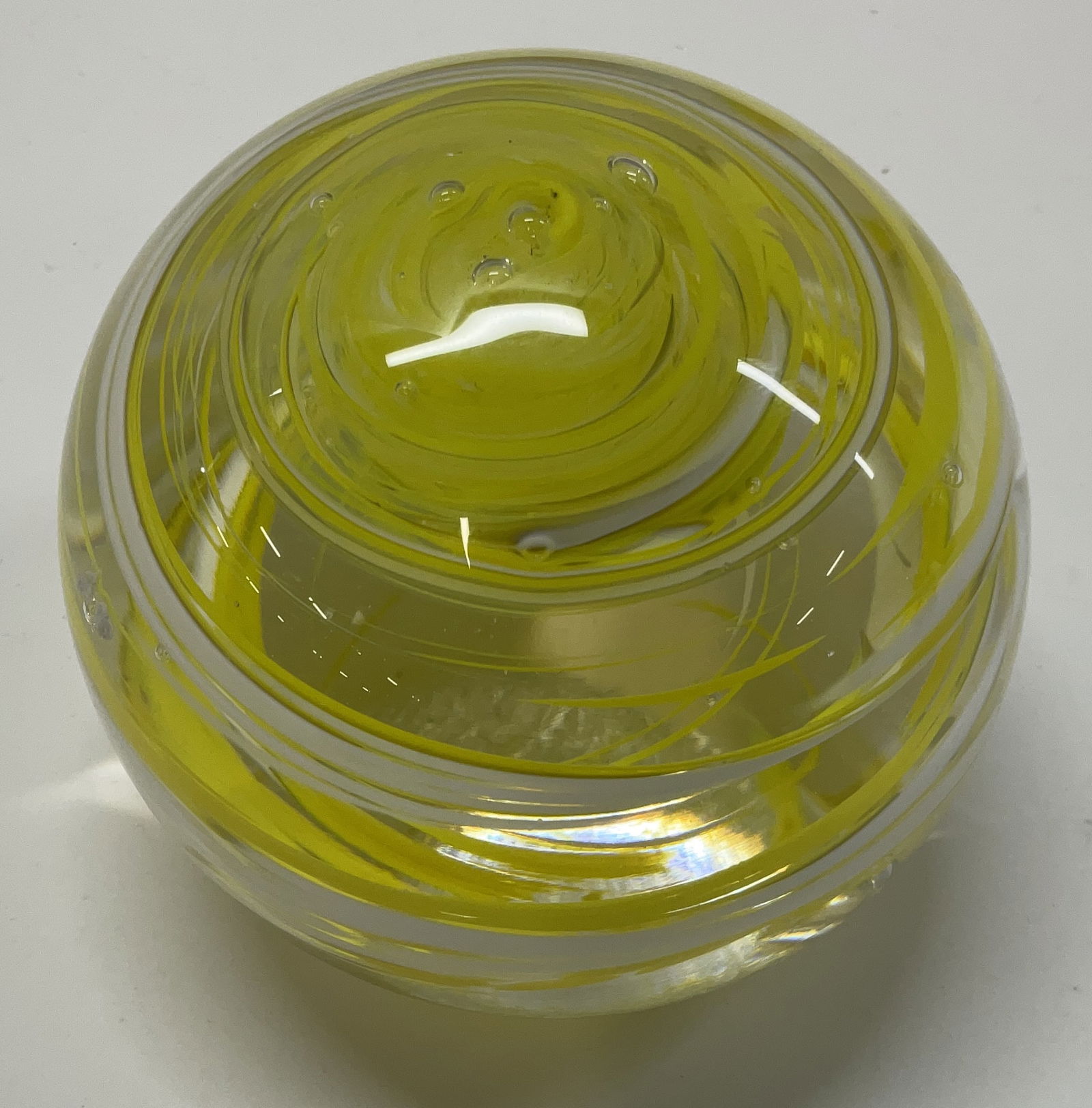 White and Yellow Swirled Art Glass Paperweight: White and Yellow Swirled Art Glass Paperweight. Murano Styled. Hand-Blown. No Visible Signature. Measures approximately 2 1/4in H x 3 1/4in L. Condition consistent with exposure. Yellow
