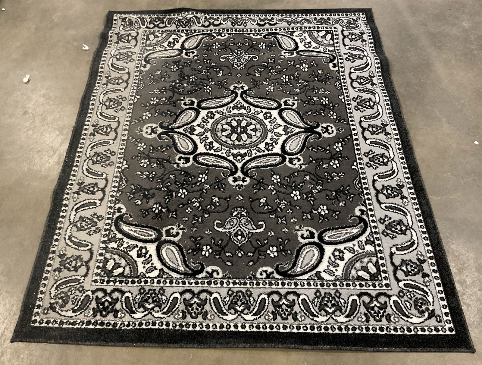 Vanessa Black Grey Floral Area Rug Turkey: Vanessa black, grey and white area rug. Intricate paisley floral design. Synthetic pile. Measures approx. 65 x 84 inches. Made in Turkey. Wear including discoloration, residue, losses. Vanessa