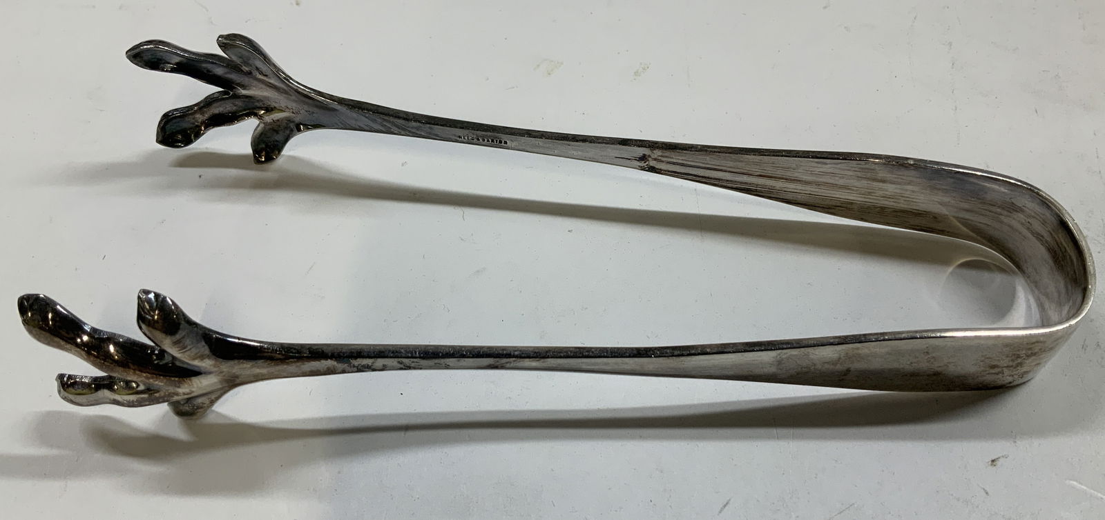 Vtg Reed & Barton Silver Plated Sugar Tongs: Vintage Reed & Barton silver-plated sugar tongs feature a chicken feet design. Signed & marked on underside. Reads, REED & BARTON. Surface wear consistent to age, use & exposure. Measurements: