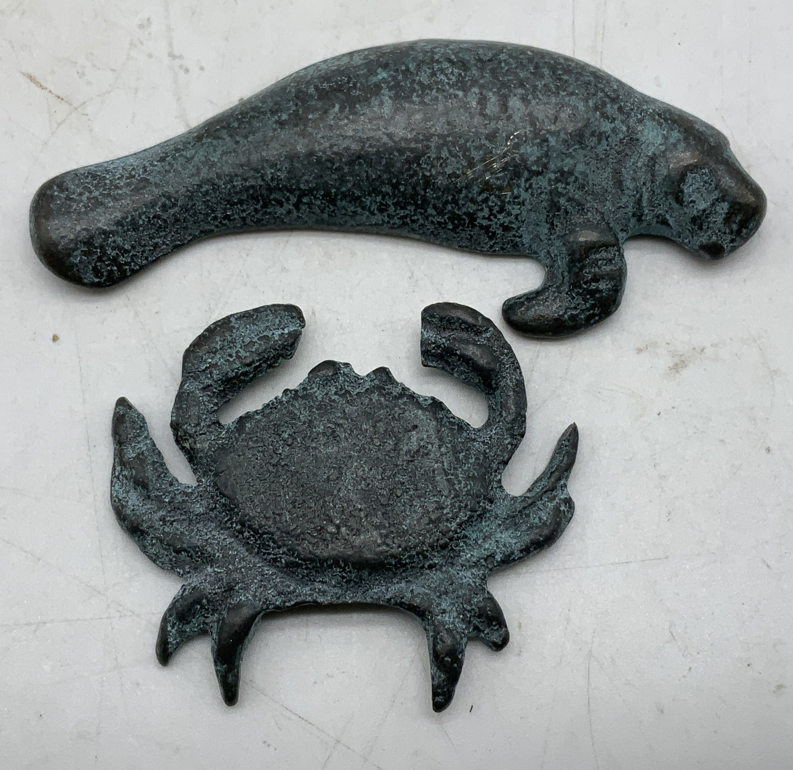 Lot 2 San Pacific Intl. Manatee & Crab Fig: Lot includes, 2 San Pacific International figurines depicting a manatee & crab. Appears to be possible brass. Green patina. Signed & marked on underside. Reads, SAN PACIFIC INTL SPI. Surface wear