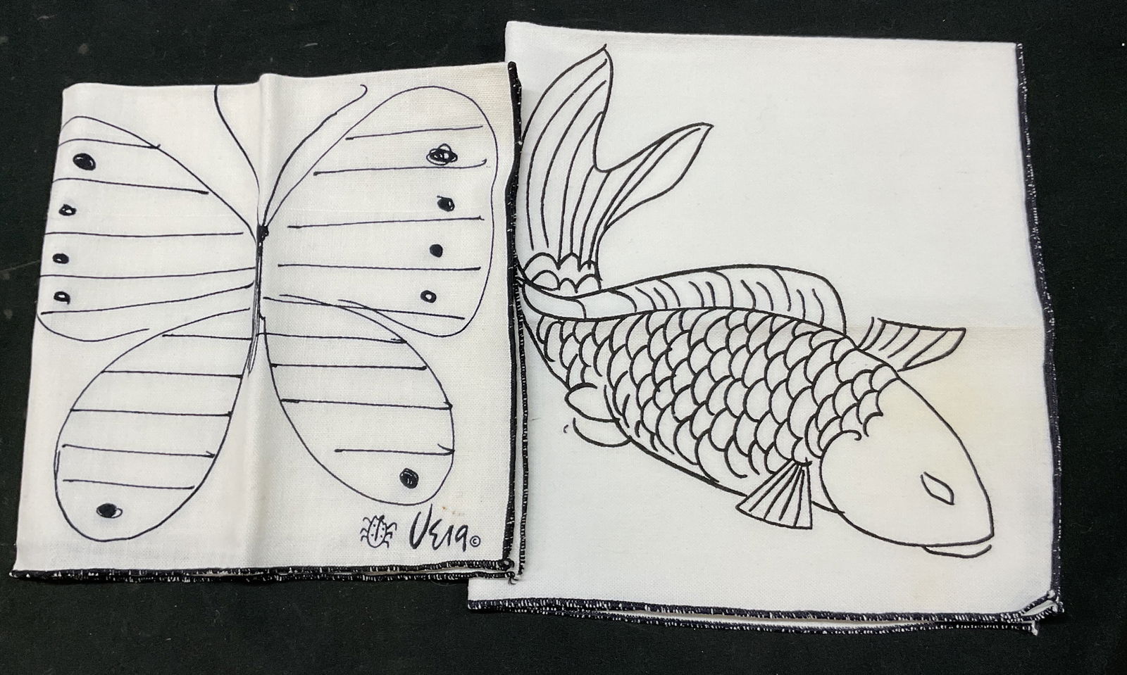 Lot 2 Vera Neumann Butterfly & Fish Linens: Lot of 2 items. Vera Neumann butterfly and fish linens. Linen material. Butterfly napkin and fish place mat. Signed. Black and white. Detailed features. Largest measures approx 17 x 18 inches. Some bl