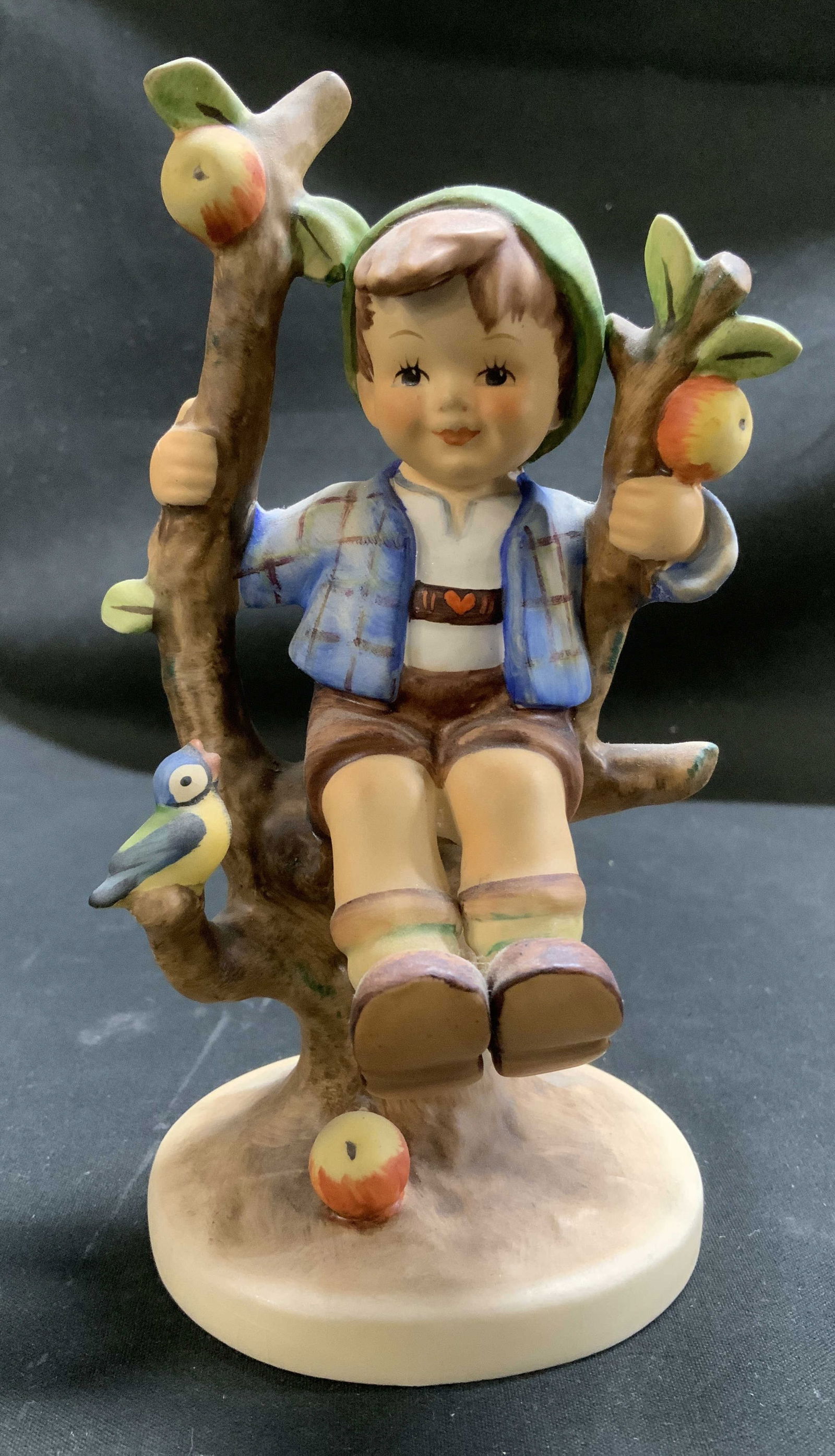 Vtg Goebel Apple Tree Boy Ceramic Fig W GERMANY: Vintage Goebel ceramic figurine featuring a young boy sitting in the branches of an apple tree. Signed & marked on underside. Reads, GOEBEL. W GERMANY. Surface wear consistent to age, use & exposure.