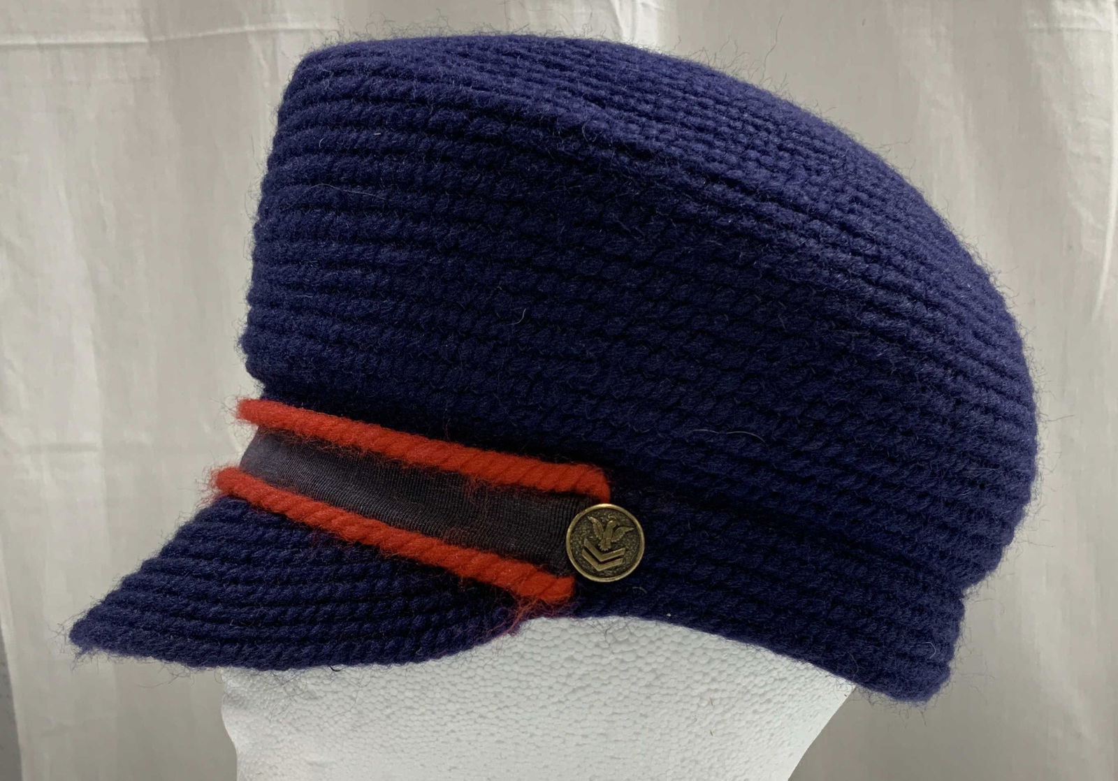 Vtg Everitt Navy Knit Newsboy Style Cap: Vintage newsboy style cap is navy toned & accented with a red trim. Gold toned eagle button on sides. Signed & marked. Reads, EVERITT. Surface wear consistent to age, use & exposure. Measurements: len