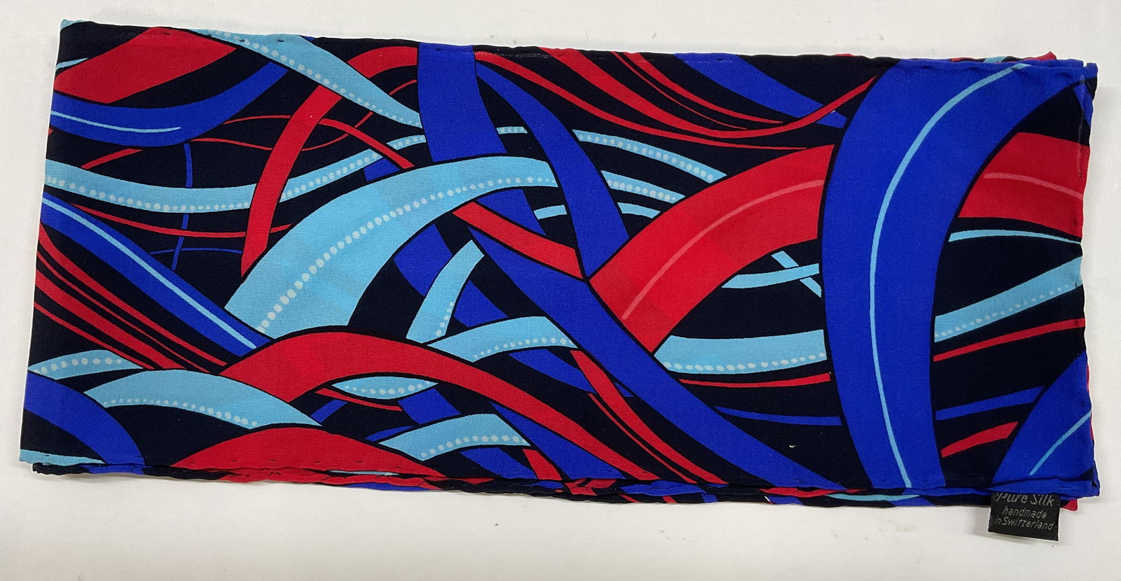 Vintage Abstract Silk Scarf Switzerland: Vintage abstract silk scarf. Hand made in Switzerland. Silk material. Abstract pattern in black, red, blue, and white. Measures approx 6 x 50 inches. Wear consistent with exposure. Scarf, silk scarf,