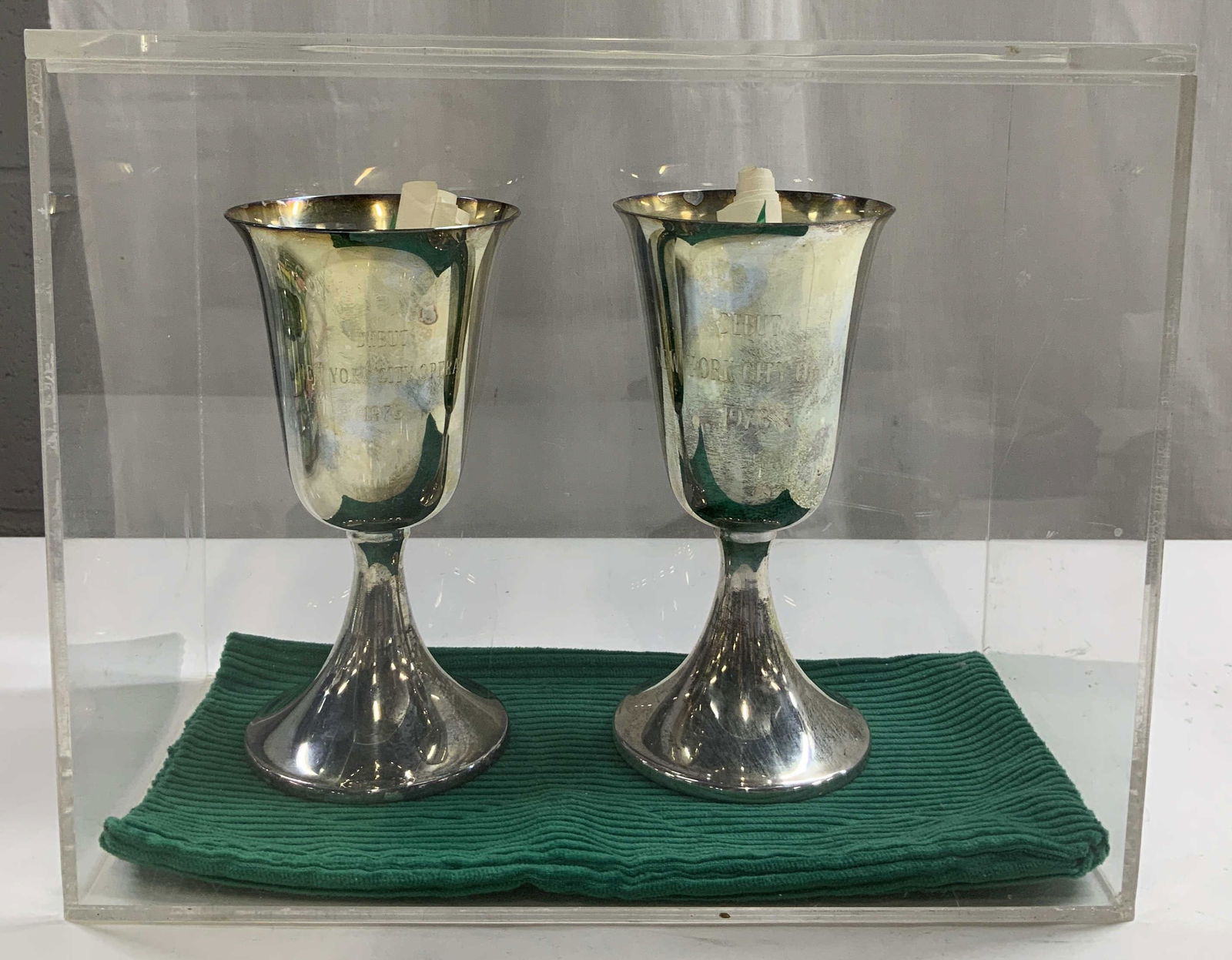Pair 1973 Debut New York City Opera Goblets W Bx: Set 2 of 1973 silver toned goblets featuring engraved text that reads, Debut New York City Opera 1973. Comes with wrapped paper that features handwritten inscriptions from NY CITY OPERA & GUILD. Goble