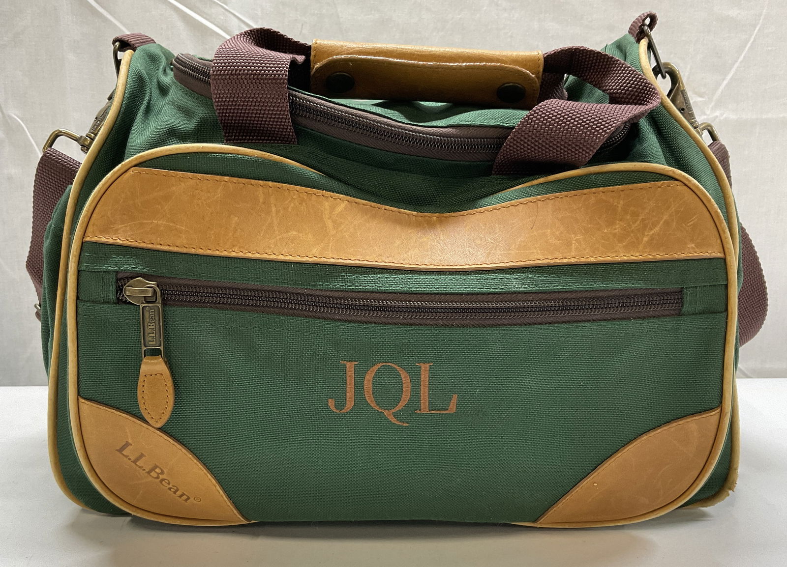 VTG L.L. Bean Nylon and Leather Duffel Bag: VTG L.L. Bean Nylon and Leather Green Duffel Bag. Custom monogram JQL embroidered on front. Tag reads LLB#0BHR9 100% Nylon exclusive of decoration and leather. Measures approximately 10.5in H x