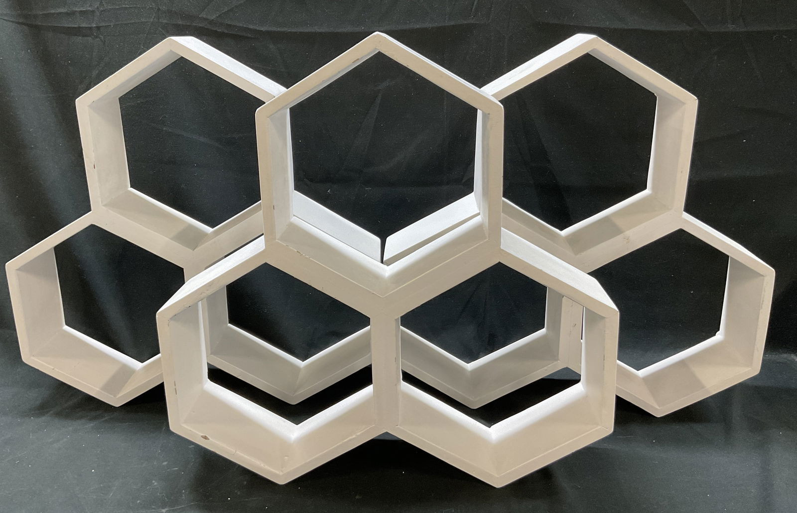 Lot 3 Vtg Wooden Honeycomb Wall Shelves India: Lot of 3 vintage wooden honeycomb wall shelves. Marked made in India. Honeycomb or hexagonal shape. Wood painted white. Hooks on backside. Faceted edges. Measures approx 4 x 17 x 18 inches. Wear to su