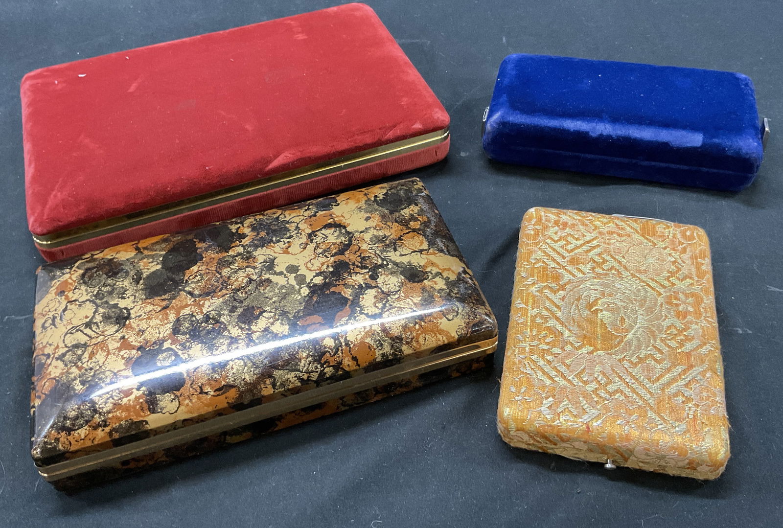 Lot 4 Mele, Mikimoto Assorted Jewelry Boxes: Lot of 4 assorted jewelry boxes. Brands include Mele and Mikimoto, marked on surfaces. Shapes, size, color, and material vary. Largest measures approx 7 x 10 x 1.5 inches. Wear to all surfaces.