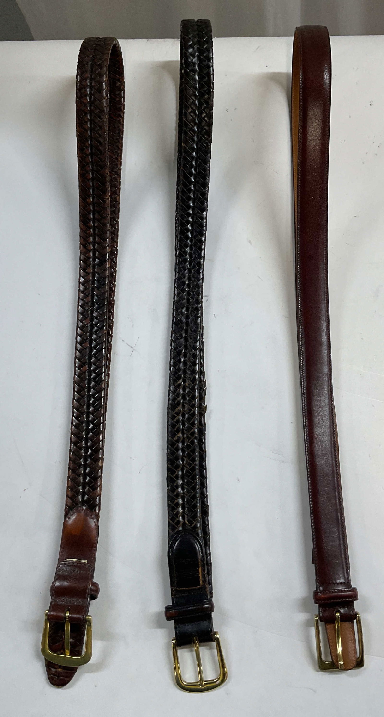 Lot 3 L.L. Bean, Trafalgar Brown Leather Belts: Lot of 3 brown leather belts. One marked Trafalgar, size 42, additional information on surface that reads illegibly. Two L.L. Bean belts, marked size 38. Gold toned buckles. Braided texture pattern. W